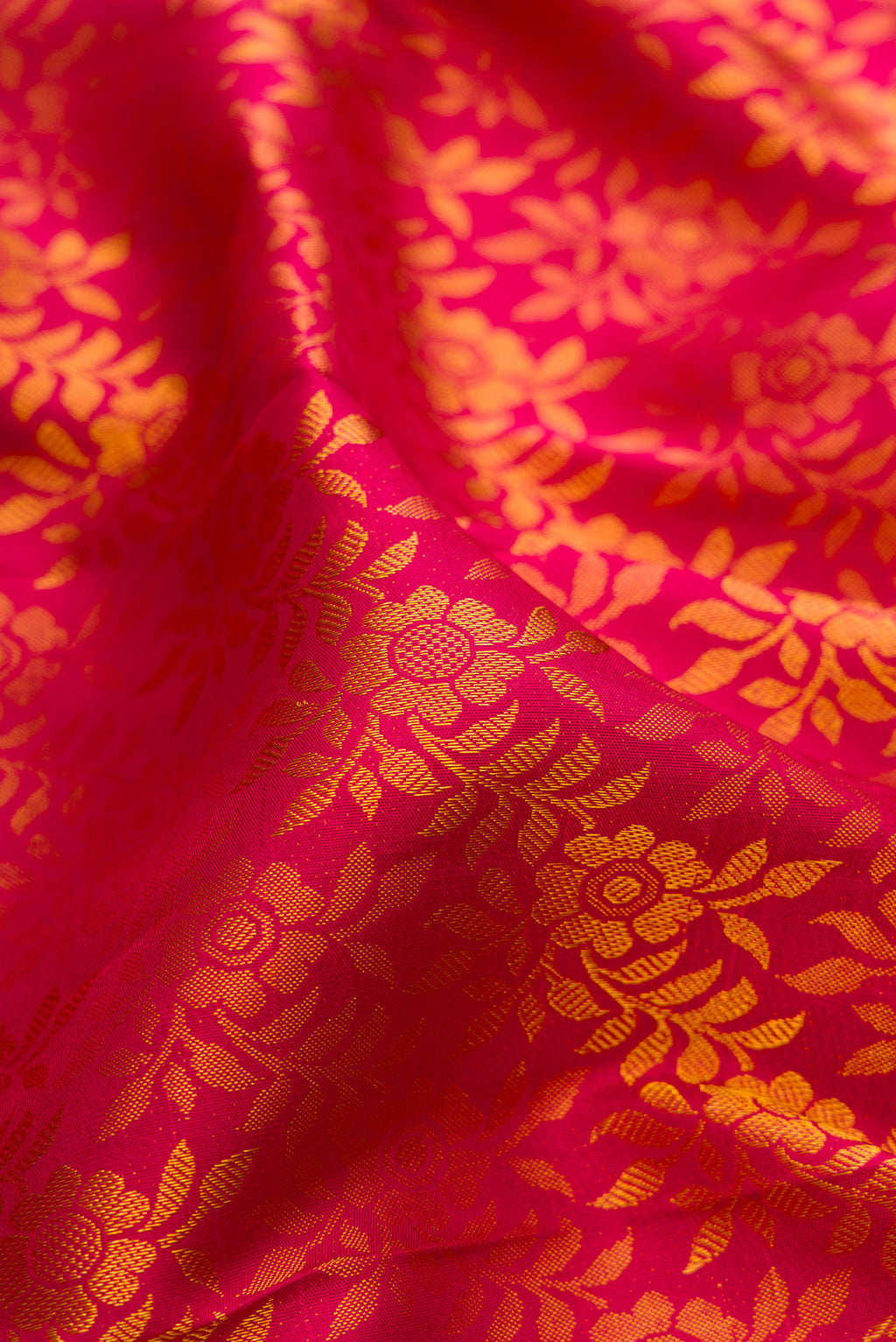 Close up of Dark Pink Kanjivaram Silk Saree with Zari Brocade on the body and Zari Border.  displaying folds