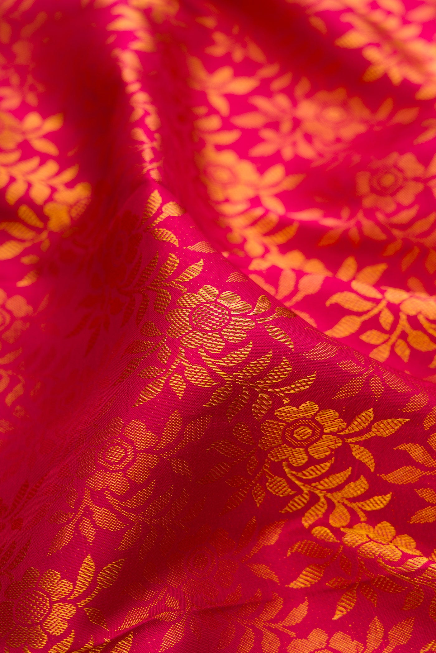 Close up of Dark Pink Kanjivaram Silk Saree with Zari Brocade on the body and Zari Border.  displaying folds