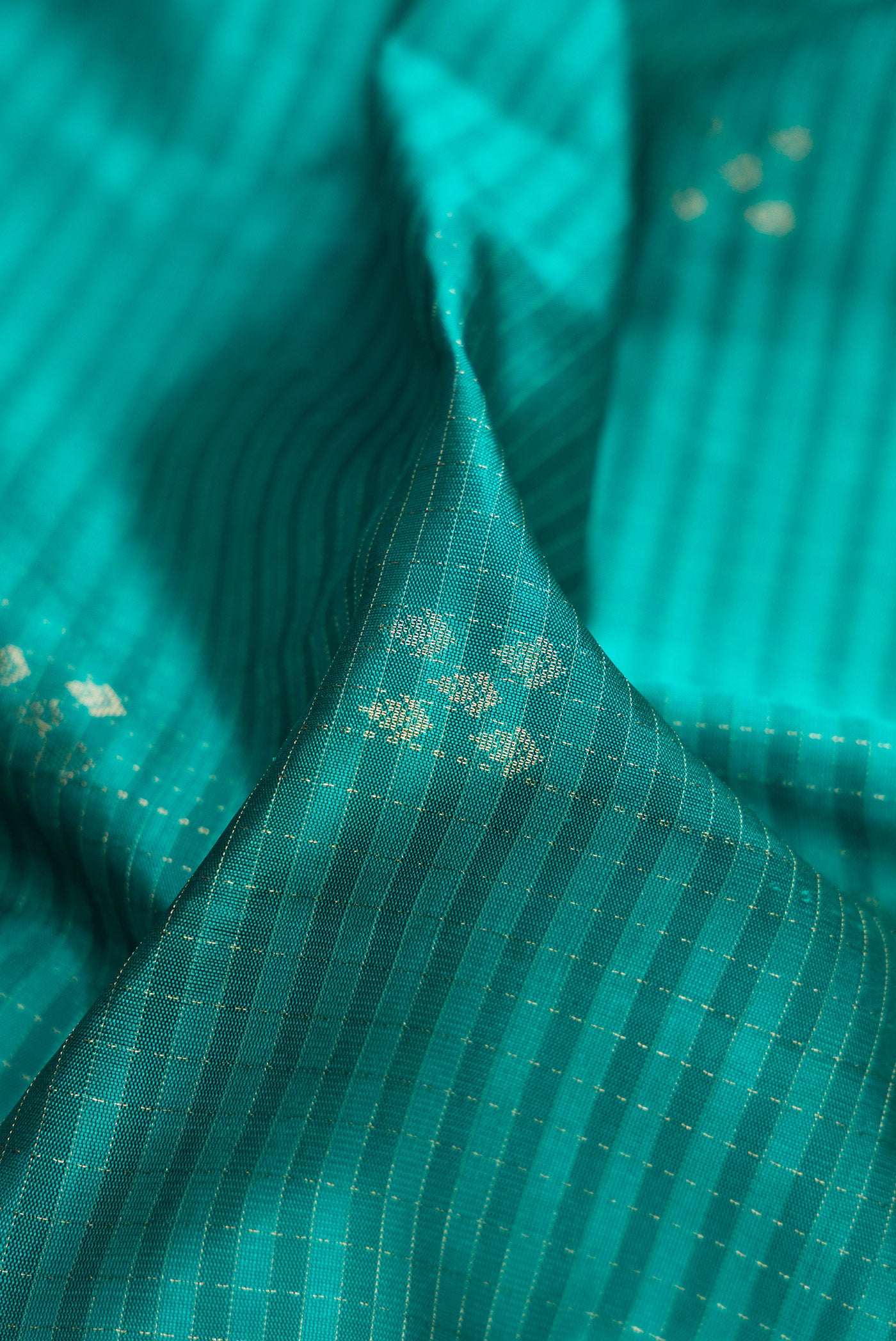 Close up of Peacock Blue Soft Silk Saree with Checked design on the body and Plain Border.  displaying folds