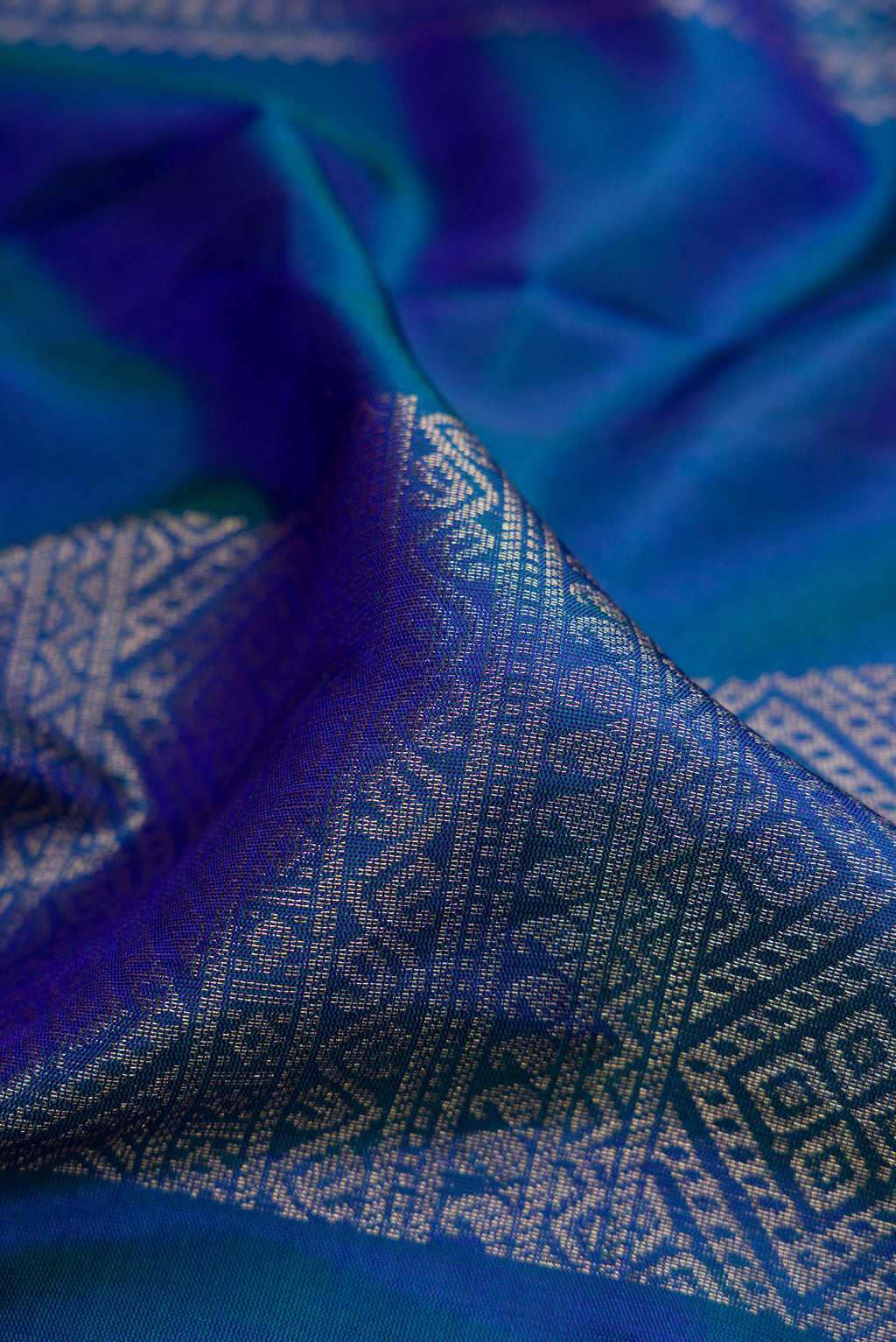 Close up of Navy Blue Soft Silk Saree with Zari Butta on the body and Fancy Border.  displaying folds