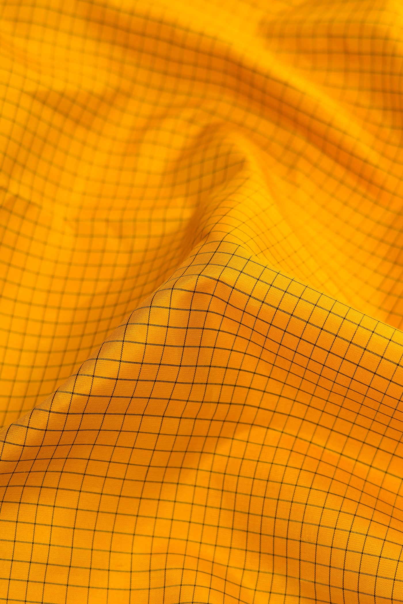 Close up of Pure Silk Pure Zari Yellow Dual Tone Kanjivaram Saree with Checked design on the body and Zari And Thread Border.  displaying folds