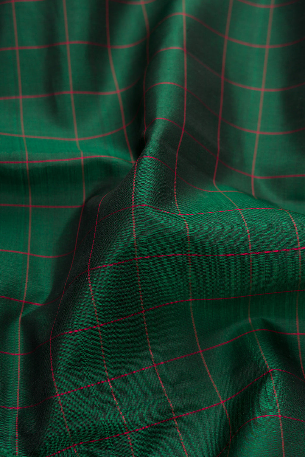 Close up of Green, Maroon & Burgundy Dual Tone Kanjivaram Silk Saree with Checked design on the body and Ganga Jamuna Border.  displaying folds