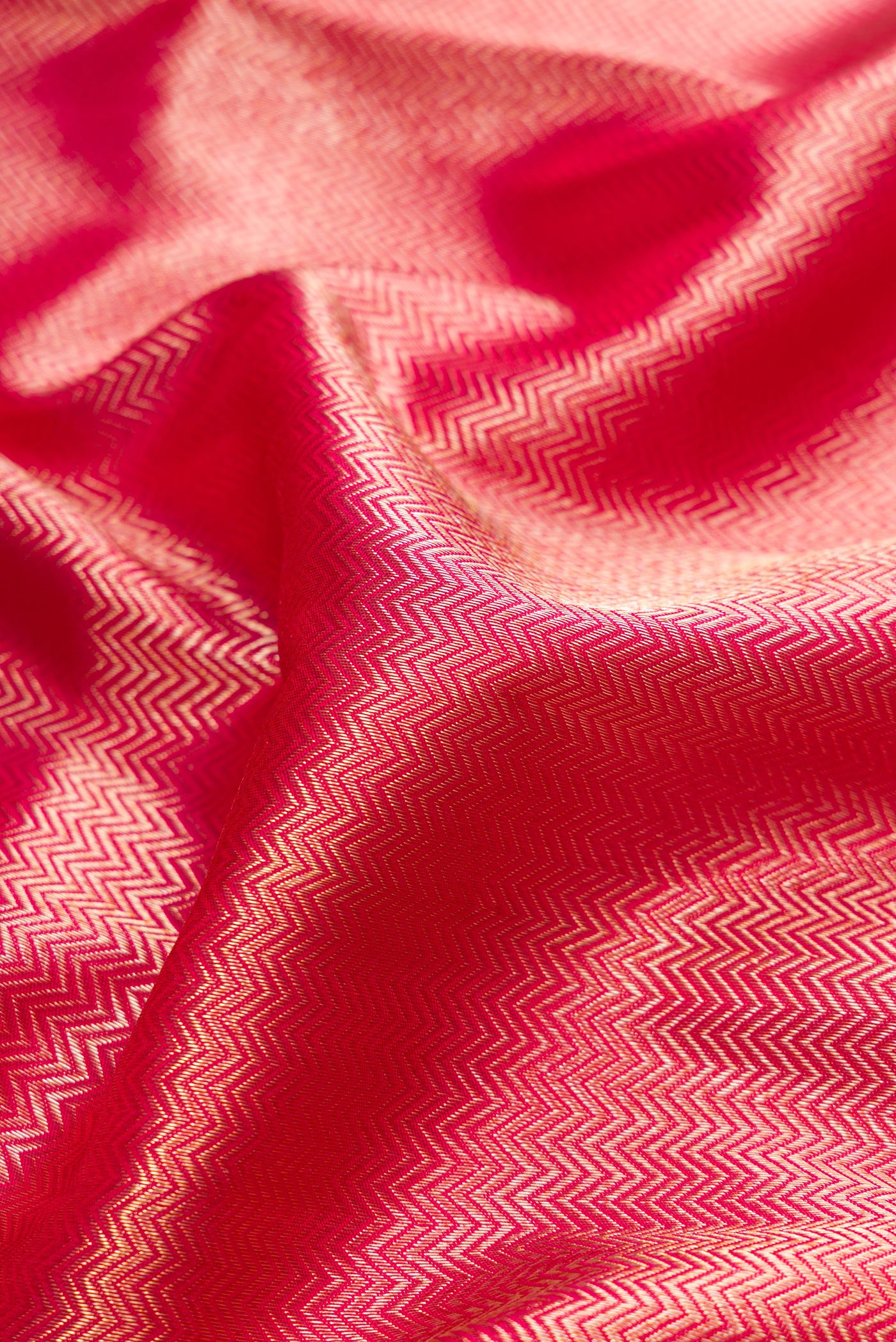 Close up of Pink Dual Tone Kanjivaram Tissue Silk Saree with Zari Brocade on the body and Paithani Border.  displaying folds