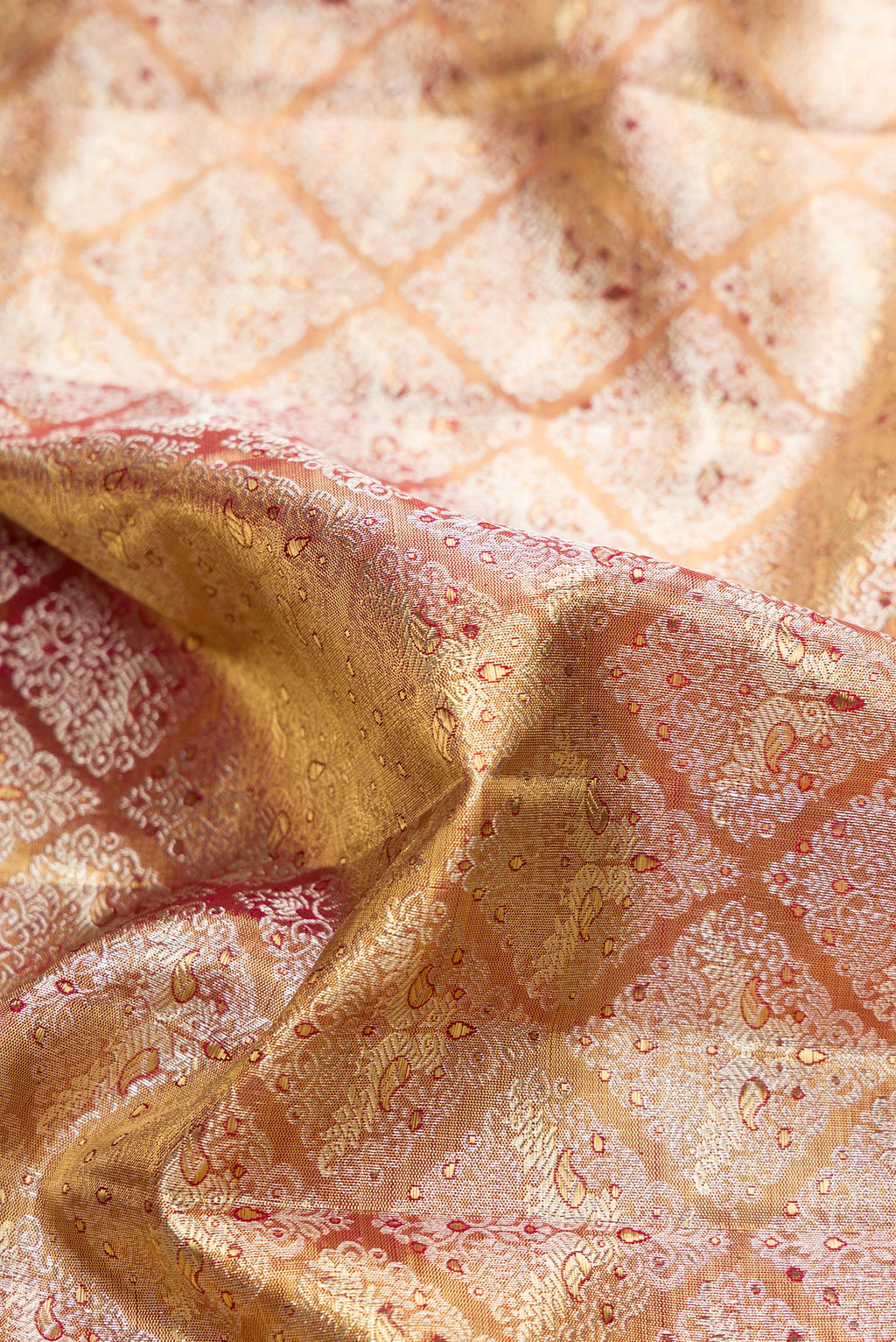 Close up of Gold Dual Tone Kanjivaram Tissue Silk Saree with Zari Brocade on the body and Zari Border.  displaying folds