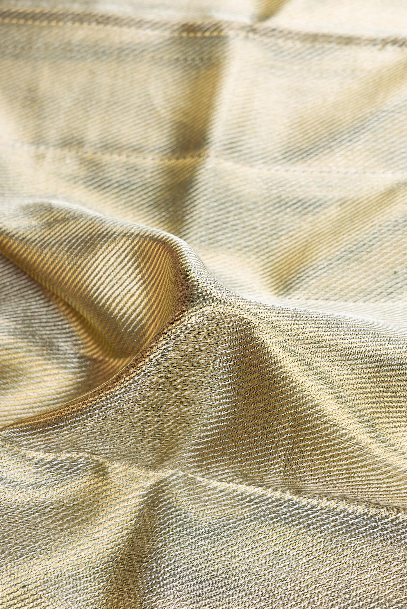 Close up of Gold Dual Tone Kanjivaram Tissue Silk Saree with Zari Brocade on the body and Temple Border.  displaying folds