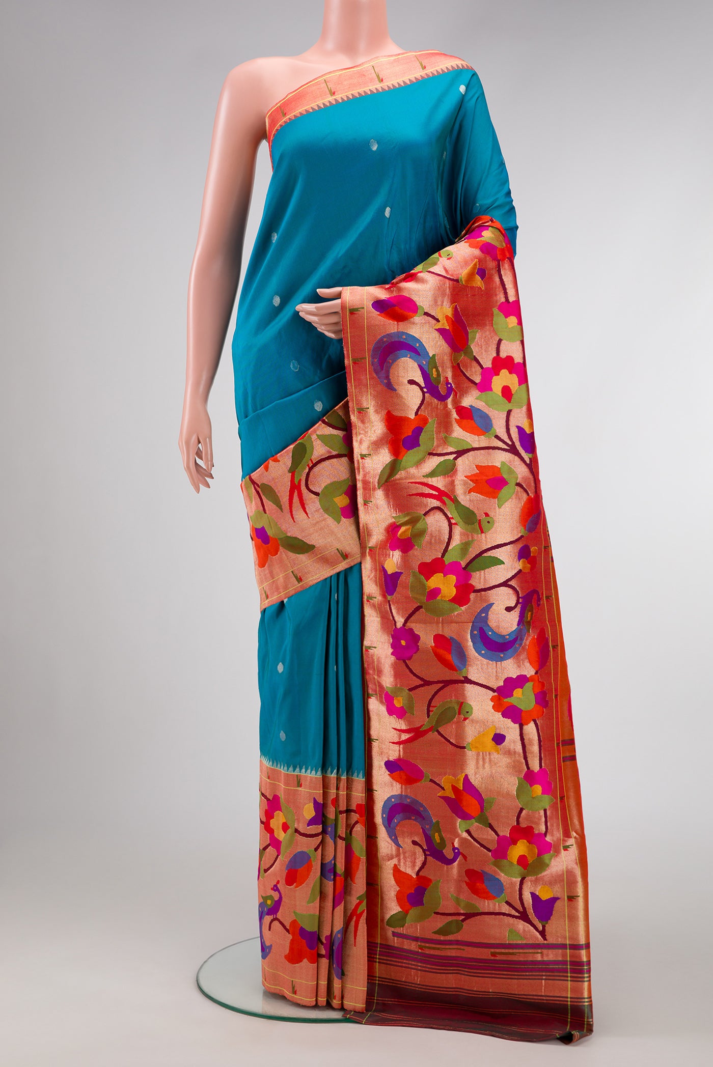 Pure Silk Pure Zari Peacock Blue Dual Tone Paithani Saree with Zari Butta on the body and Paithani Border.  displayed on a mannequin