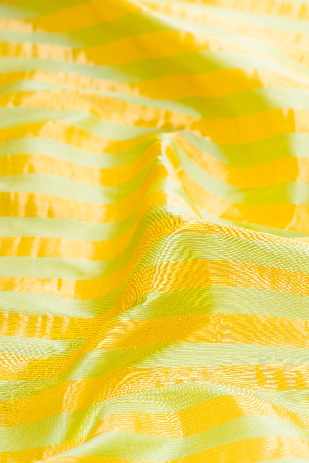 Close up of Pure Silk Pure Zari Pista Green Dual Tone Paithani Saree with Stripes on the body and Paithani Border.  displaying folds