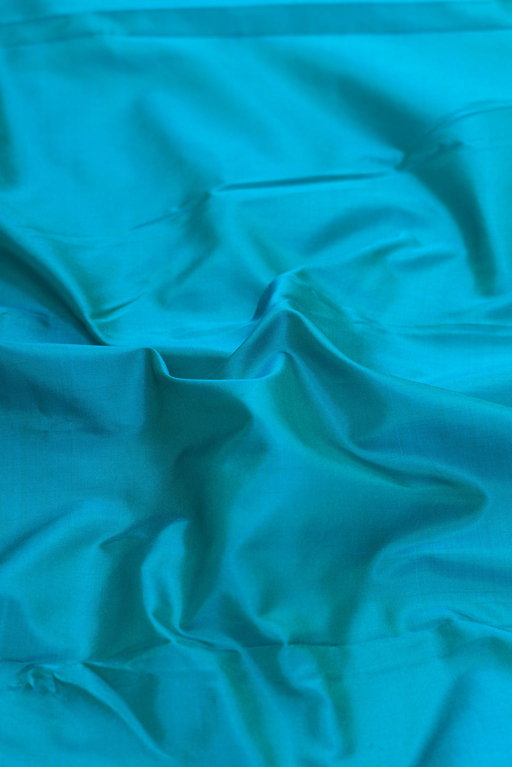 Close up of Peacock Blue Dual Tone Kanjivaram Silk Saree with Zari Butta on the body and Temple Border.  displaying folds