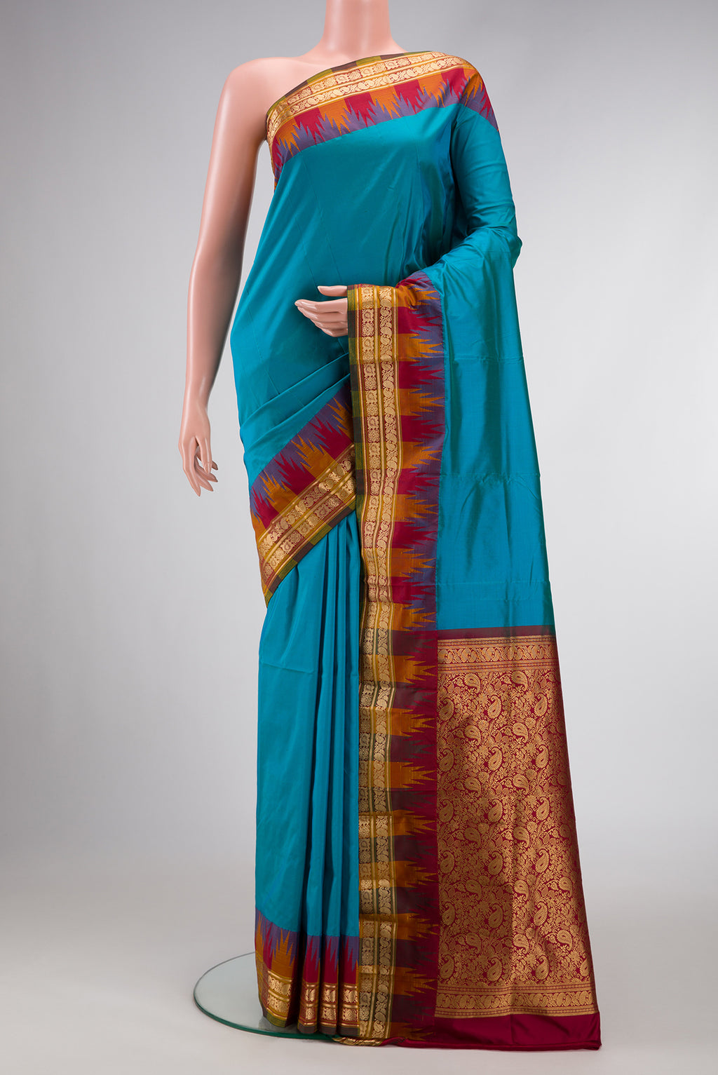 Peacock Blue Dual Tone Kanjivaram Silk Saree with Zari Butta on the body and Temple Border.  displayed on a mannequin