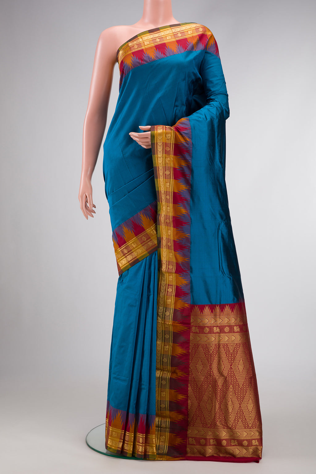Peacock Blue Dual Tone Kanjivaram Silk Saree with Zari Butta on the body and Temple Border.  displayed on a mannequin