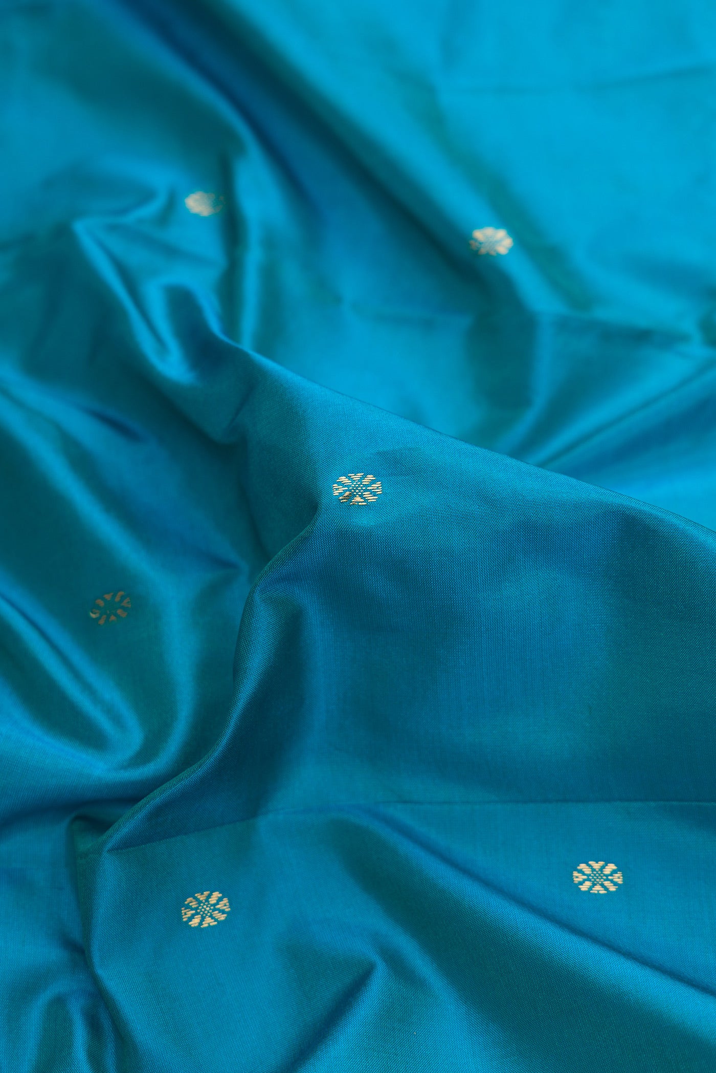 Close up of Peacock Blue Dual Tone Kanchipuram Silk Saree with Plain Body and Temple Border.  displaying folds