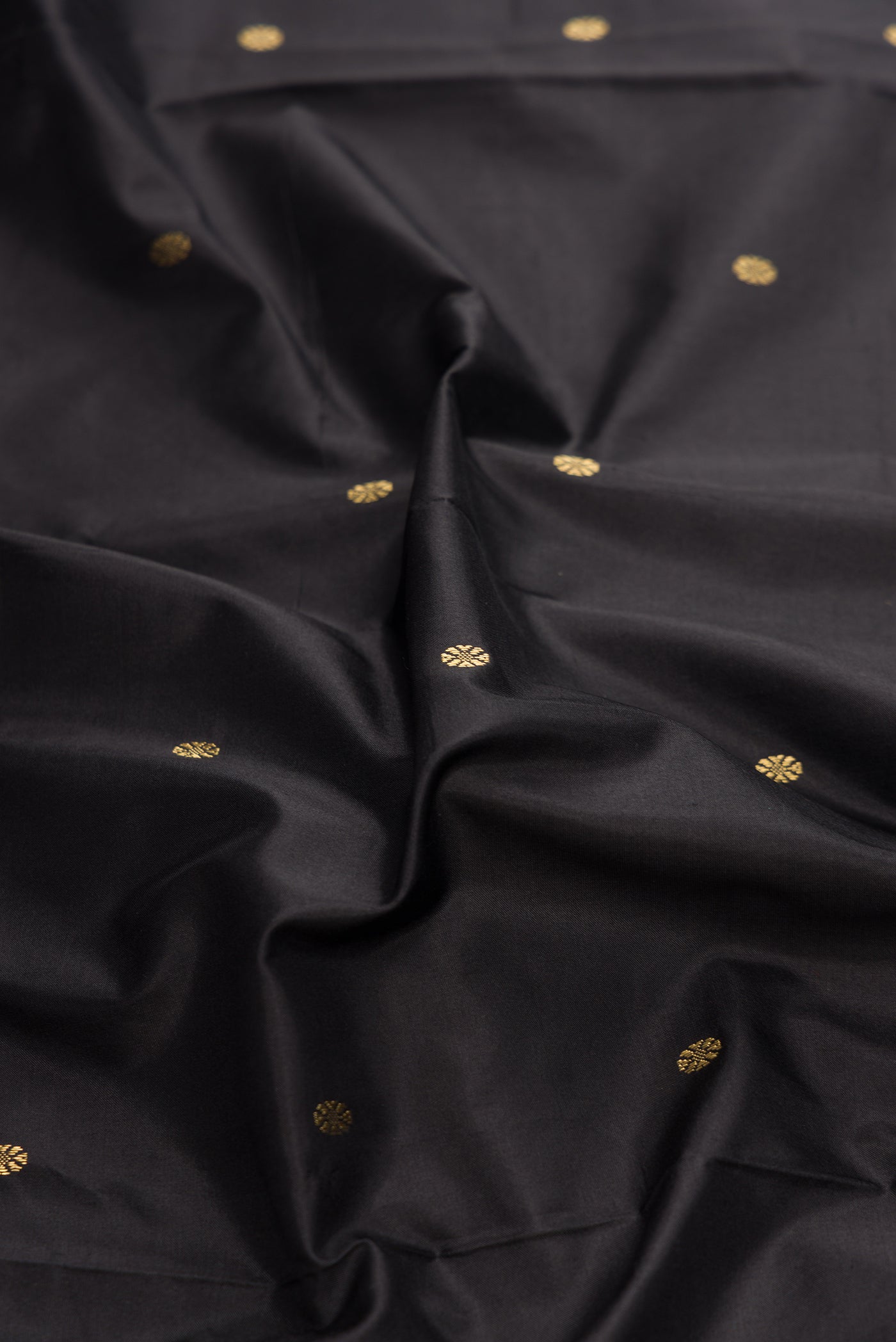 Close up of Black Dual Tone Kanchipuram Silk Saree with Zari Butta on the body and Temple Border.  displaying folds
