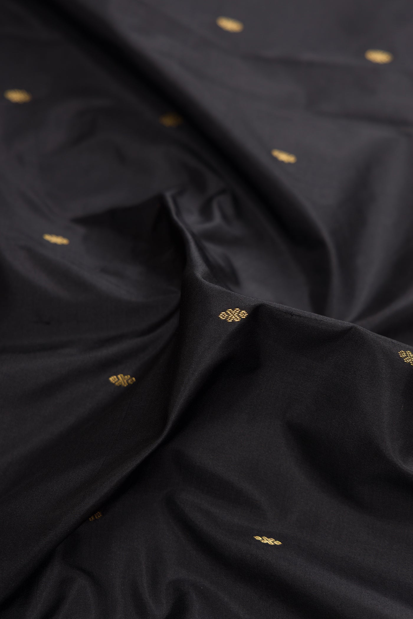 Close up of Black Dual Tone Kanchipuram Silk Saree with Zari Butta on the body and Zari Border.  displaying folds