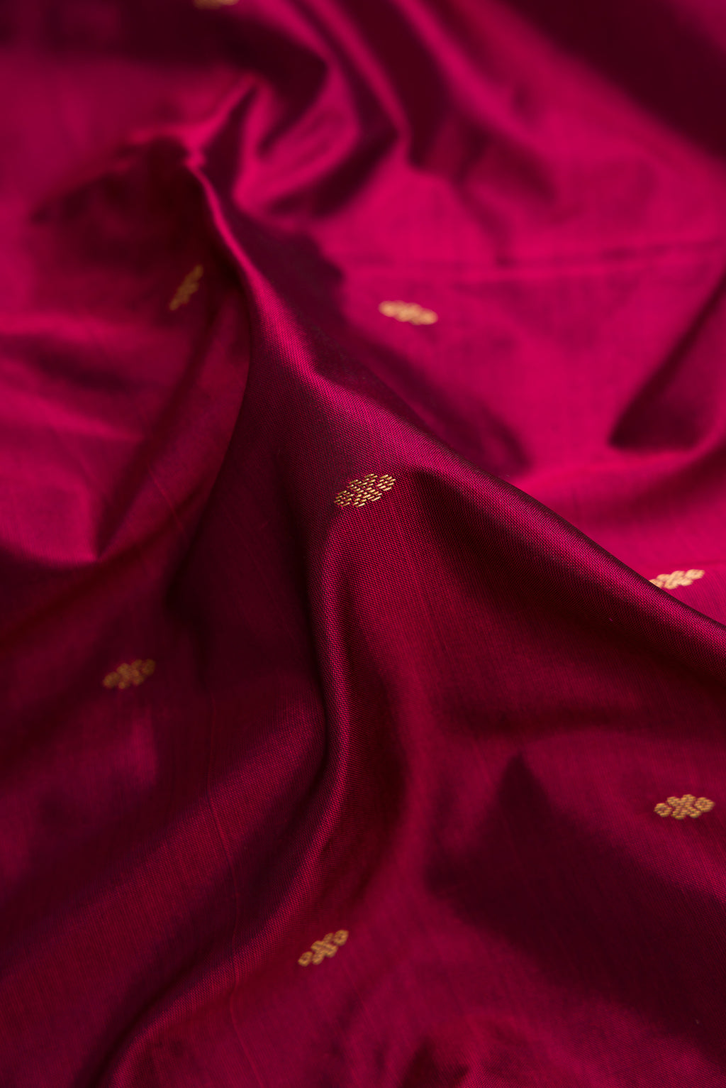 Close up of Burgundy Dual Tone Kanchipuram Silk Saree with Zari Butta on the body and Temple Border.  displaying folds