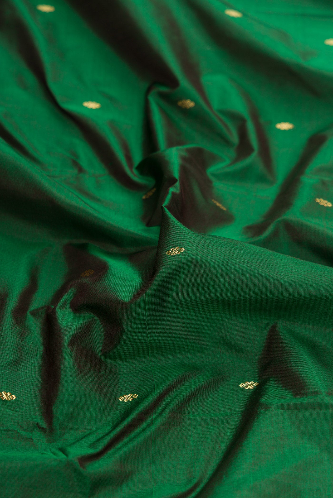 Close up of Green Dual Tone Kanchipuram Silk Saree with Zari Butta on the body and Temple Border.  displaying folds