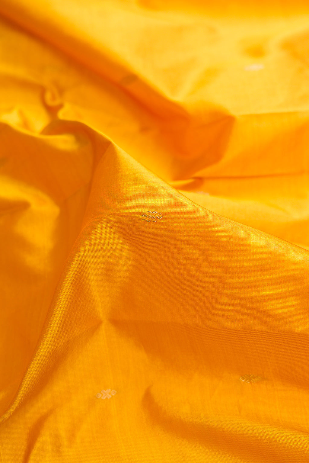 Close up of Mustard Dual Tone Kanchipuram Silk Saree with Zari Butta on the body and Temple Border.  displaying folds