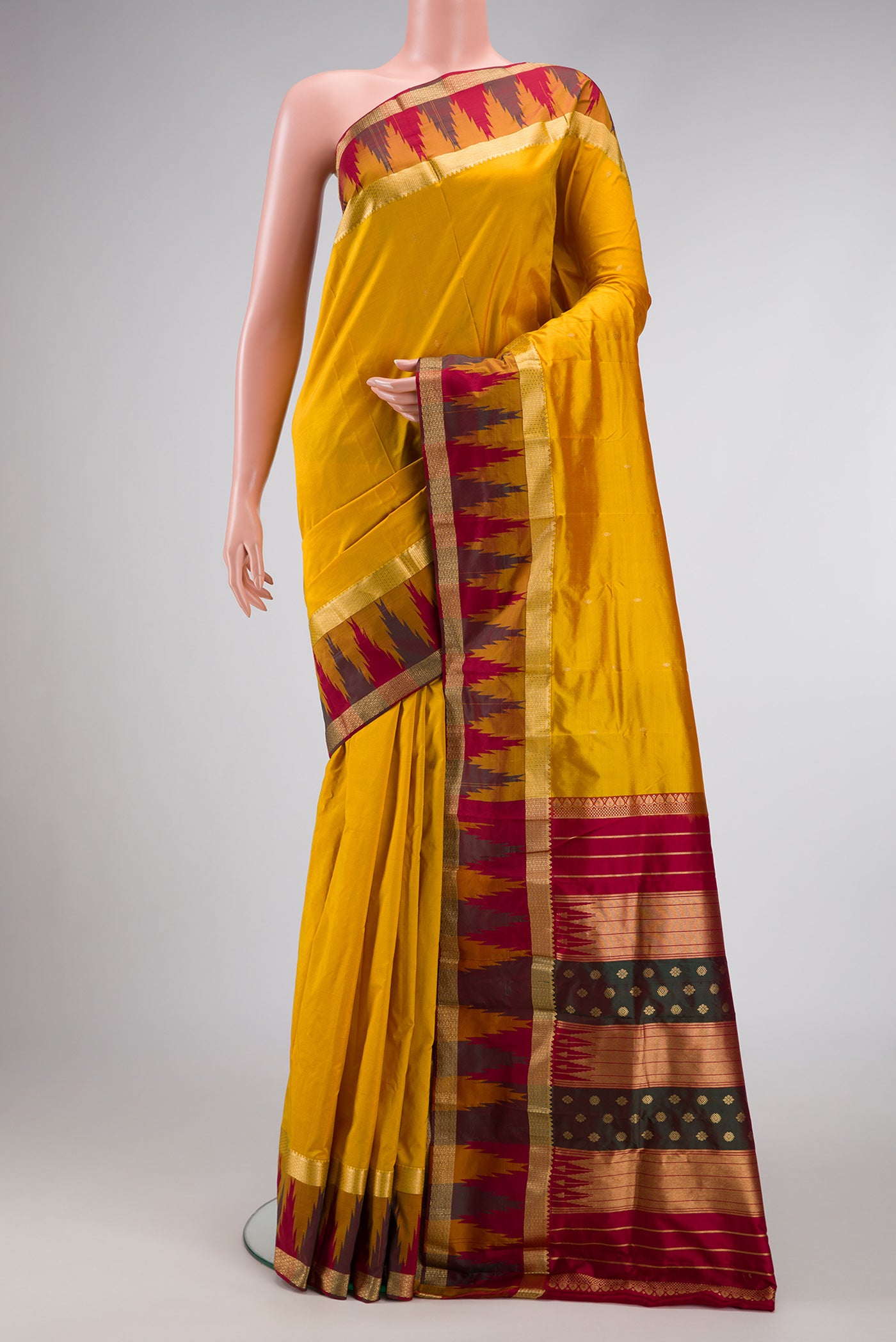 Mustard Dual Tone Kanchipuram Silk Saree with Zari Butta on the body and Temple Border.  displayed on a mannequin