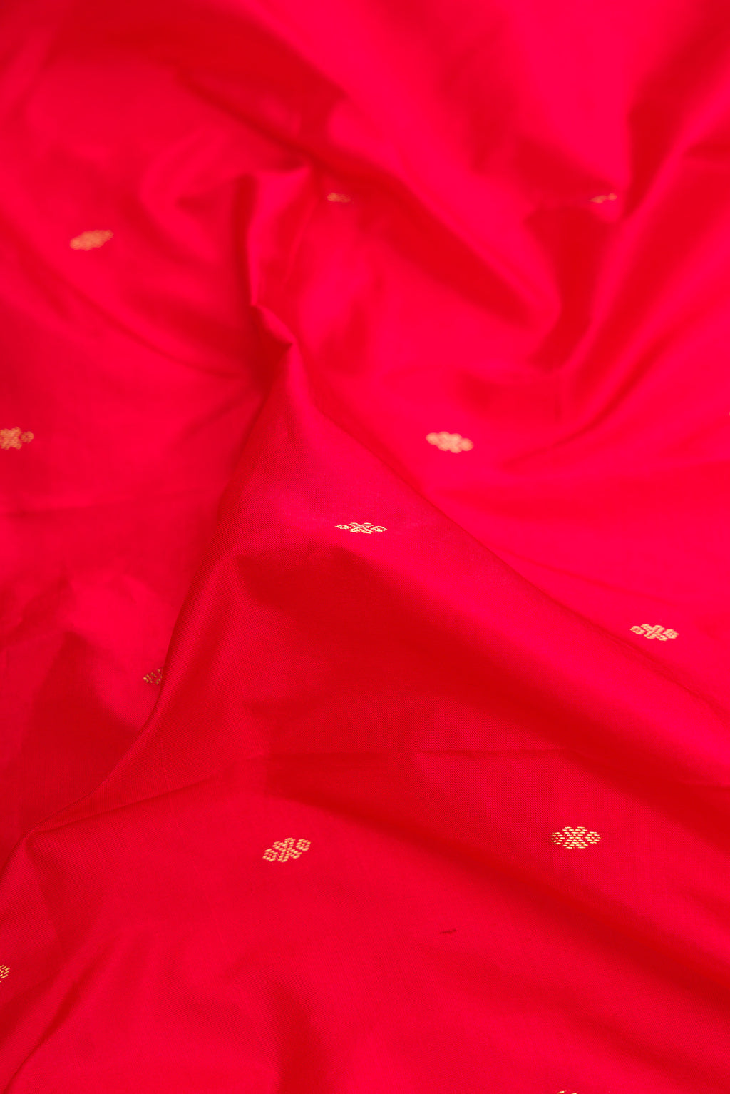 Close up of Red Dual Tone Kanchipuram Silk Saree with Zari Butta on the body and Temple Border.  displaying folds