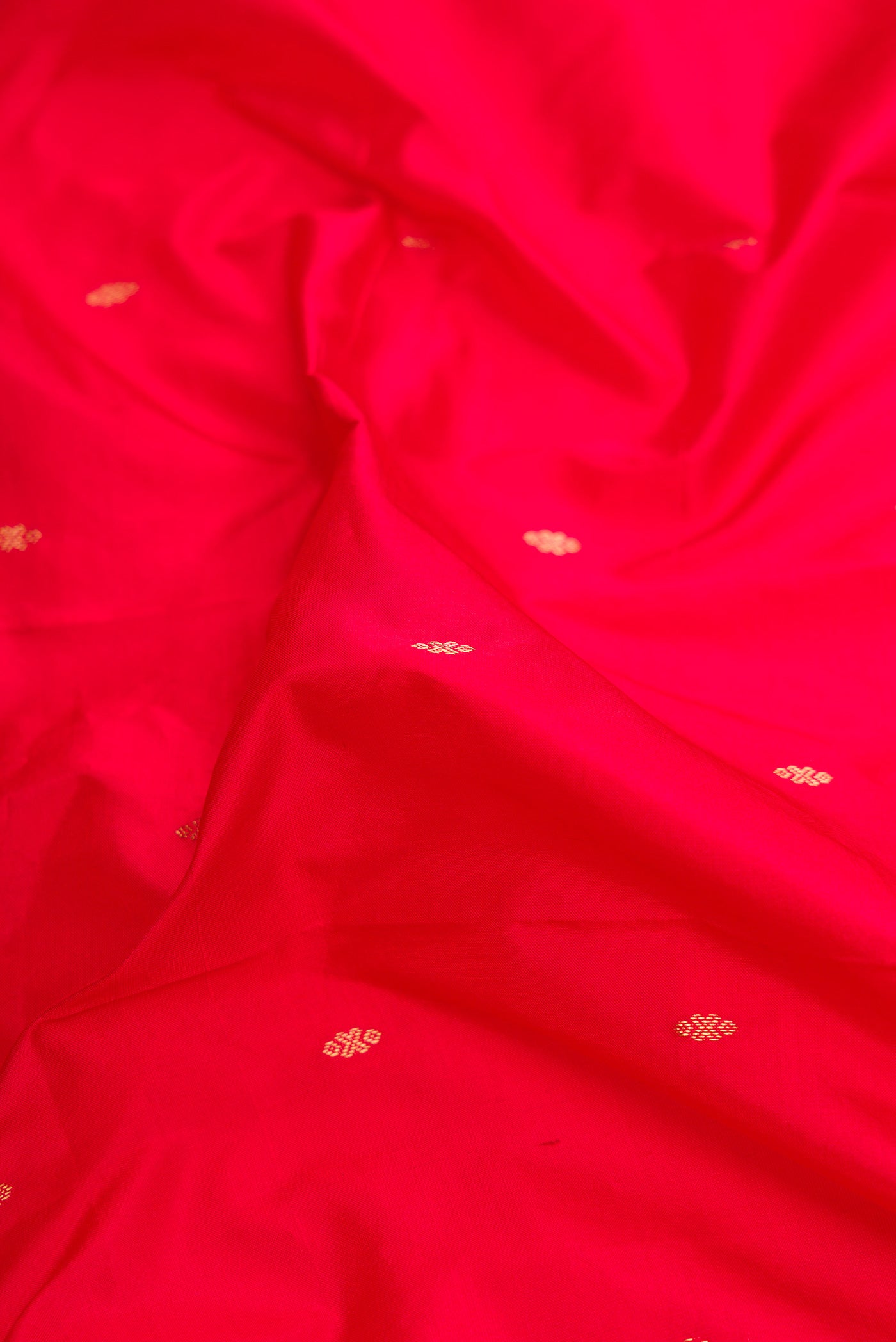 Close up of Red Dual Tone Kanchipuram Silk Saree with Zari Butta on the body and Temple Border.  displaying folds