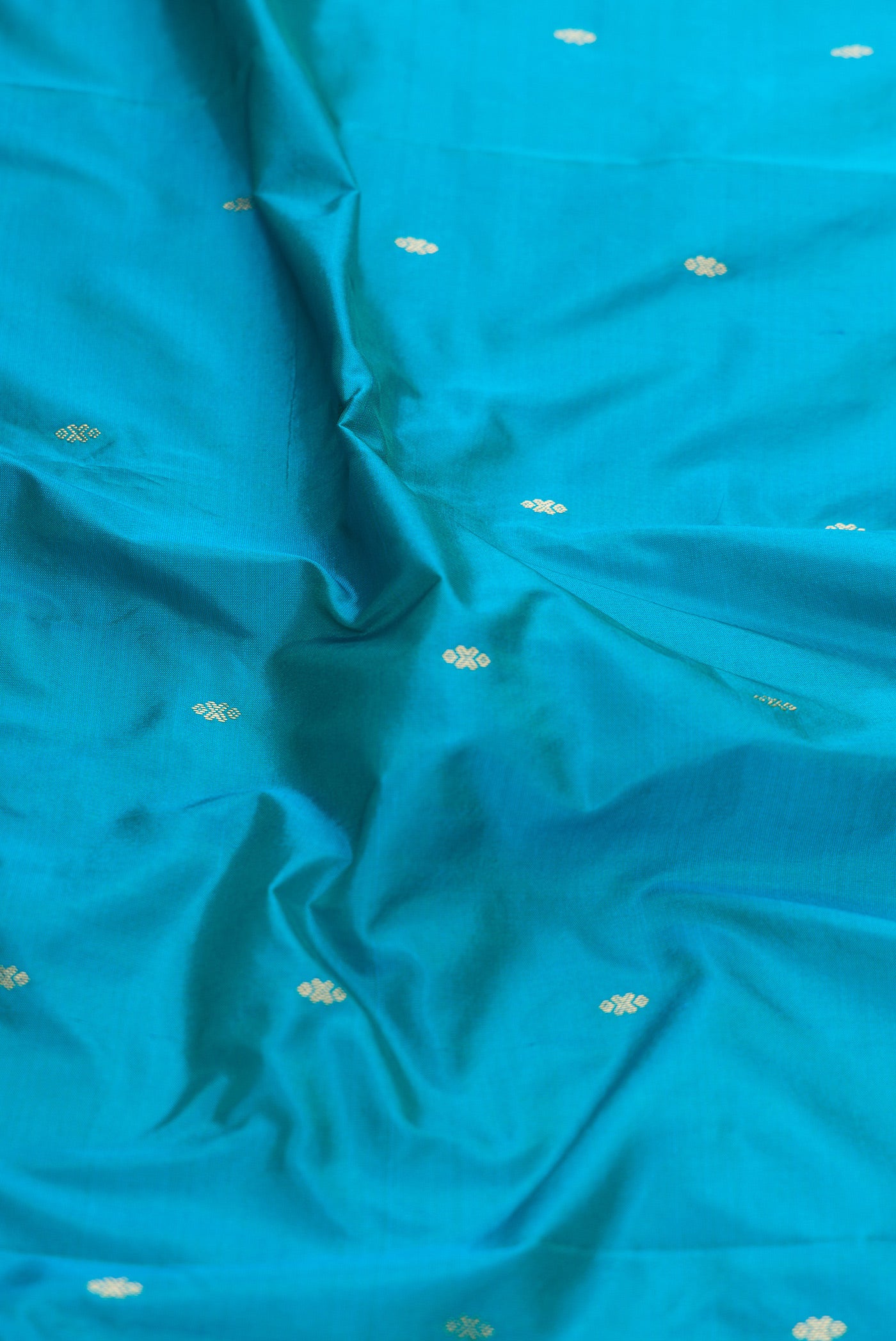 Close up of Sky Blue Dual Tone Kanchipuram Silk Saree with Zari Butta on the body and Temple Border.  displaying folds