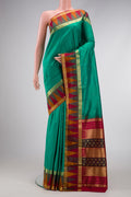 Green Dual Tone Kanchipuram Silk Saree with Zari Butta on the body and Temple Border.  displayed on a mannequin