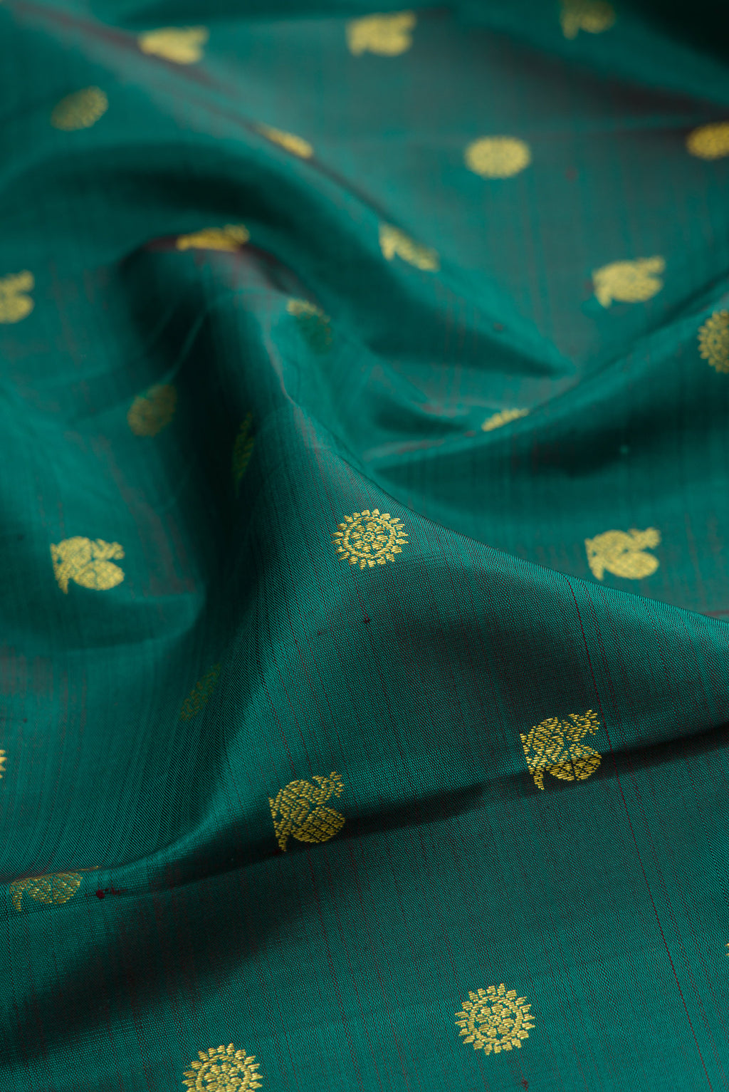 Close up of Green Kanjivaram Silk Saree with Zari Butta on the body and Zari Border.  displaying folds