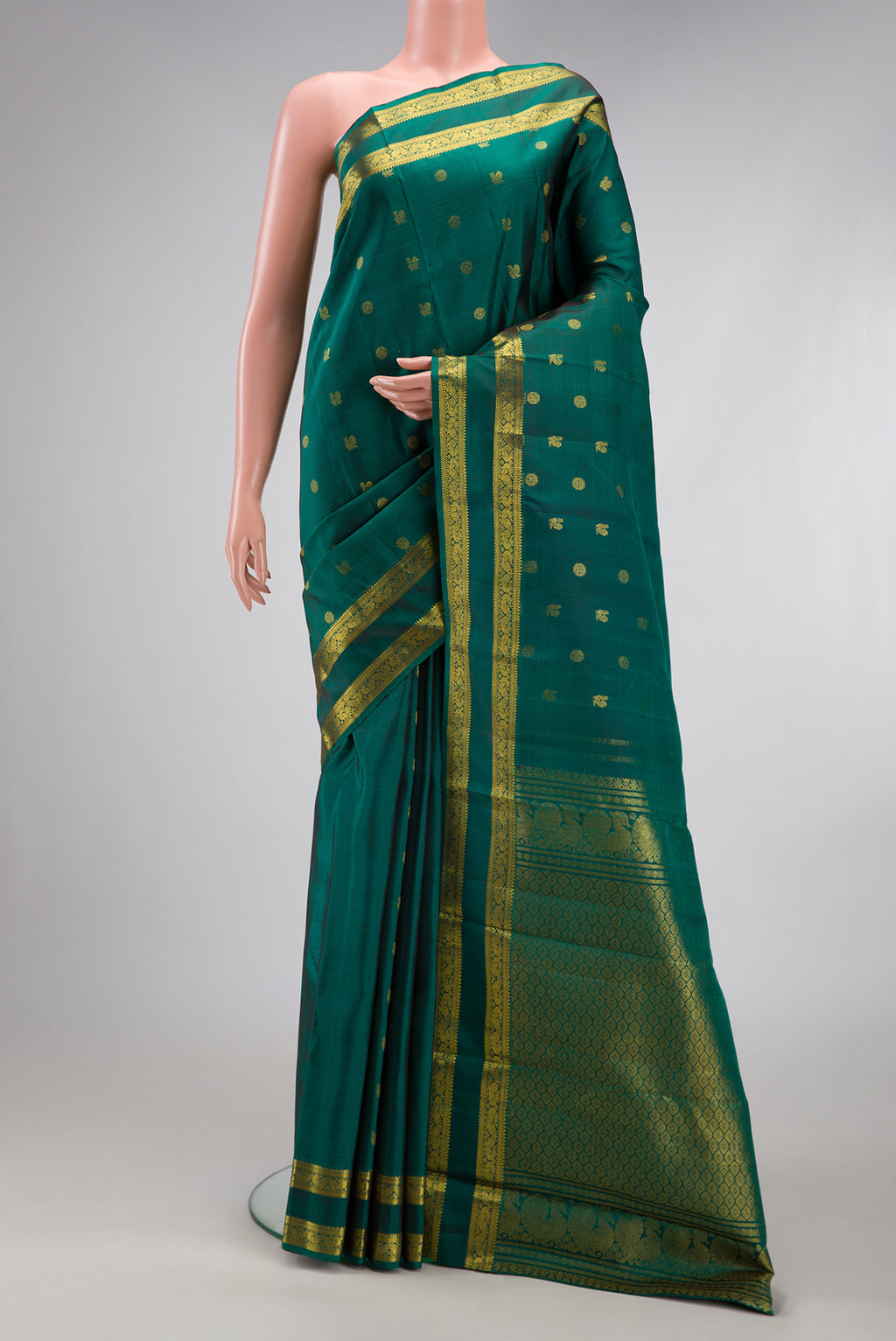 Green Kanjivaram Silk Saree with Zari Butta on the body and Zari Border.  displayed on a mannequin