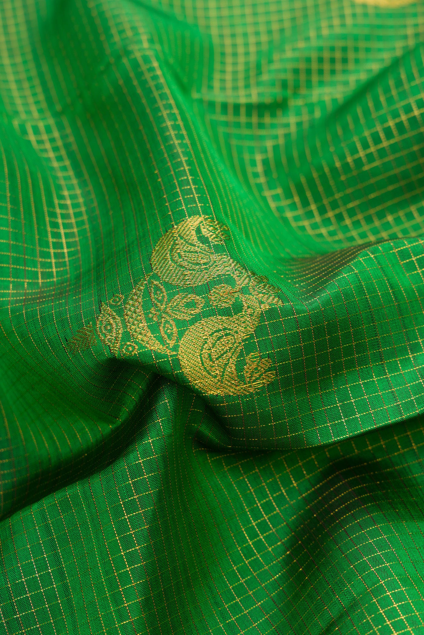 Close up of Bottle Green Dual Tone Kanchipuram Silk Saree with Checked design on the body and Zari Border.  displaying folds