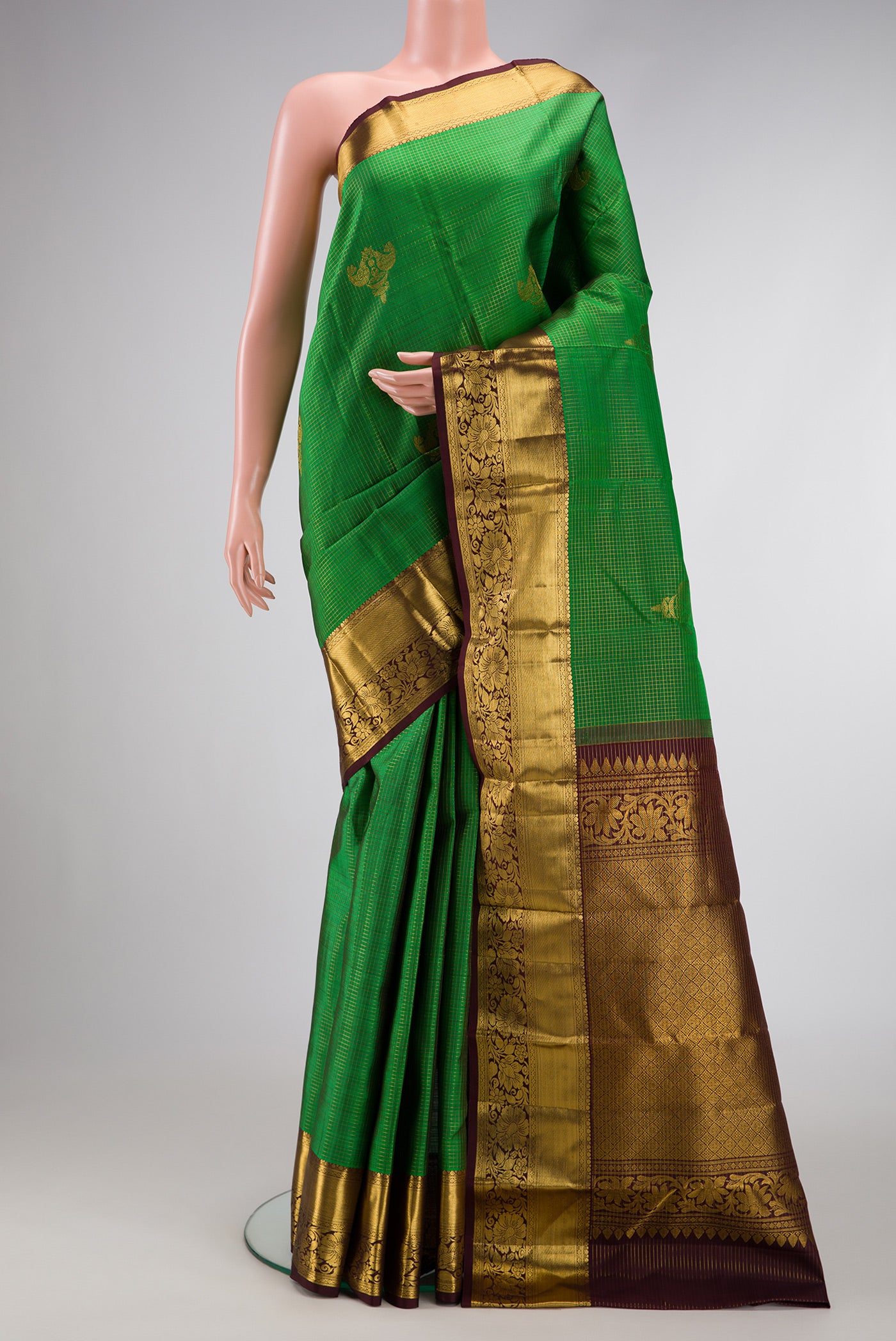Bottle Green Dual Tone Kanchipuram Silk Saree with Checked design on the body and Zari Border.  displayed on a mannequin