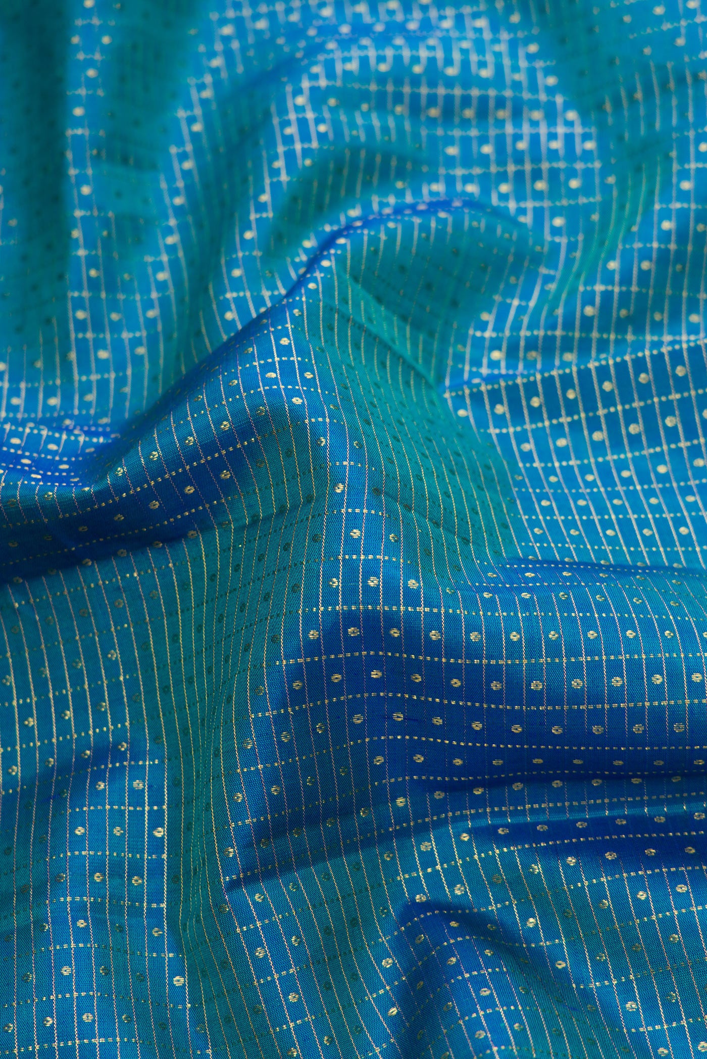 Close up of Peacock Blue Dual Tone Kanchipuram Silk Saree with Checked design on the body and Zari Border.  displaying folds