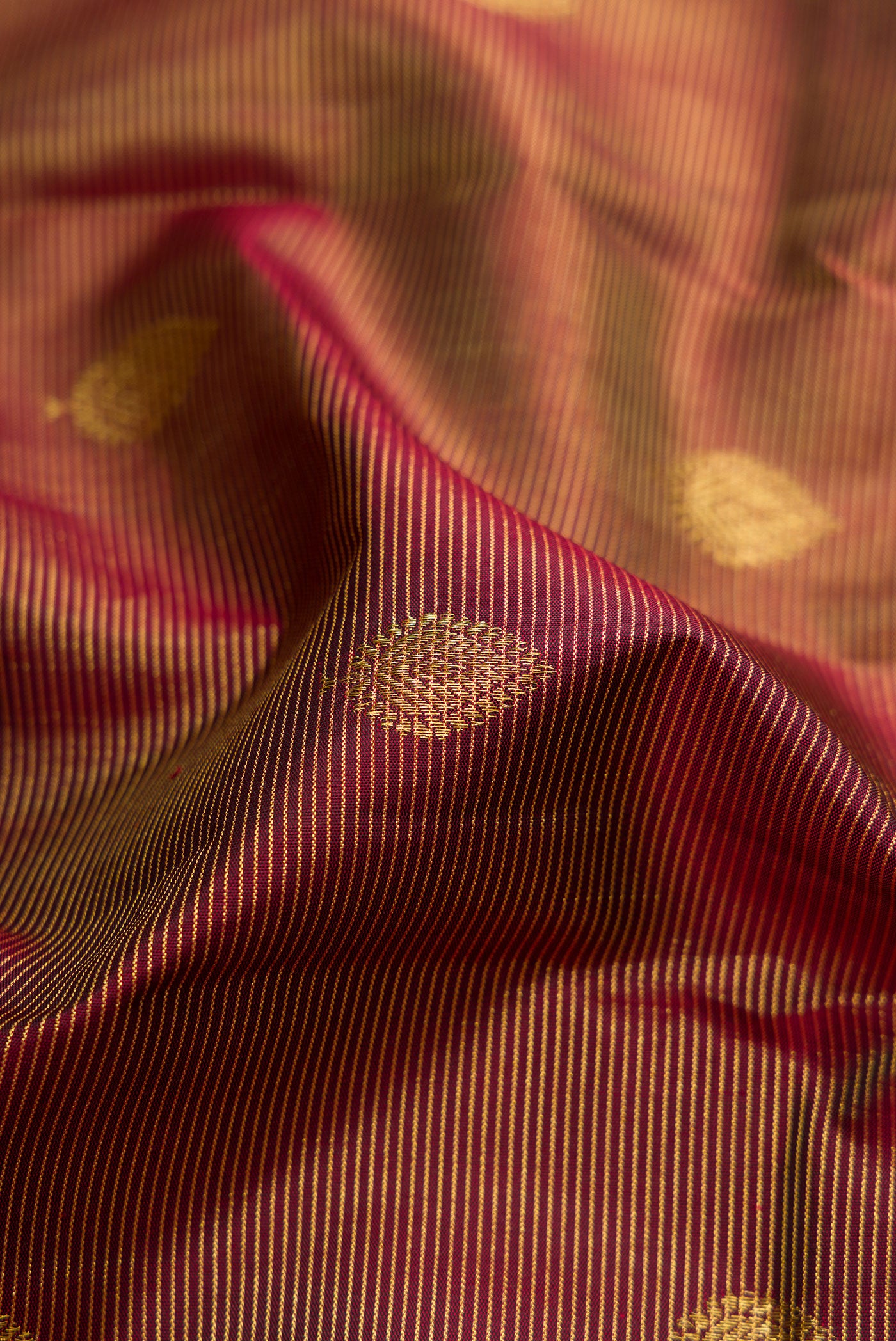 Close up of Brown Dual Tone Kanchipuram Silk Saree with Stripes on the body and Zari Border.  displaying folds