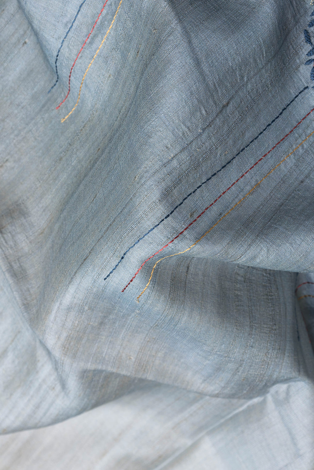 Close up of Grey Dual Tone Tussar Silk Saree with Embroidery on the body and Fancy Border.  displaying folds