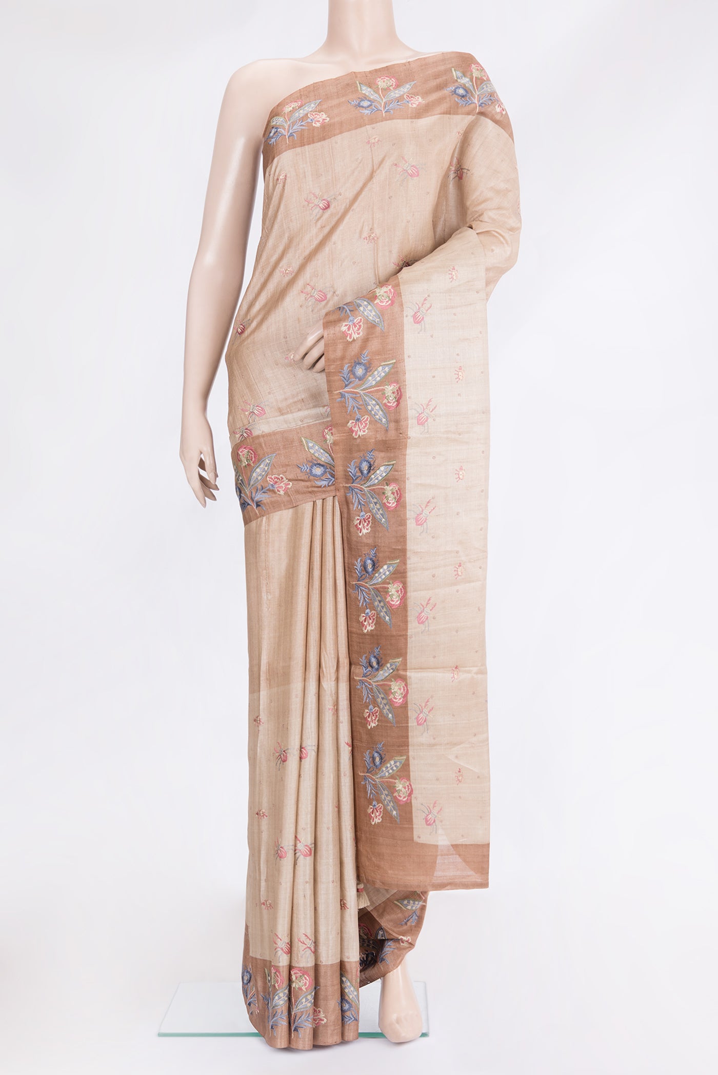 Beige Tussar Silk Saree with Embroidery on the body and Embroidery Border.  displayed on a mannequin
