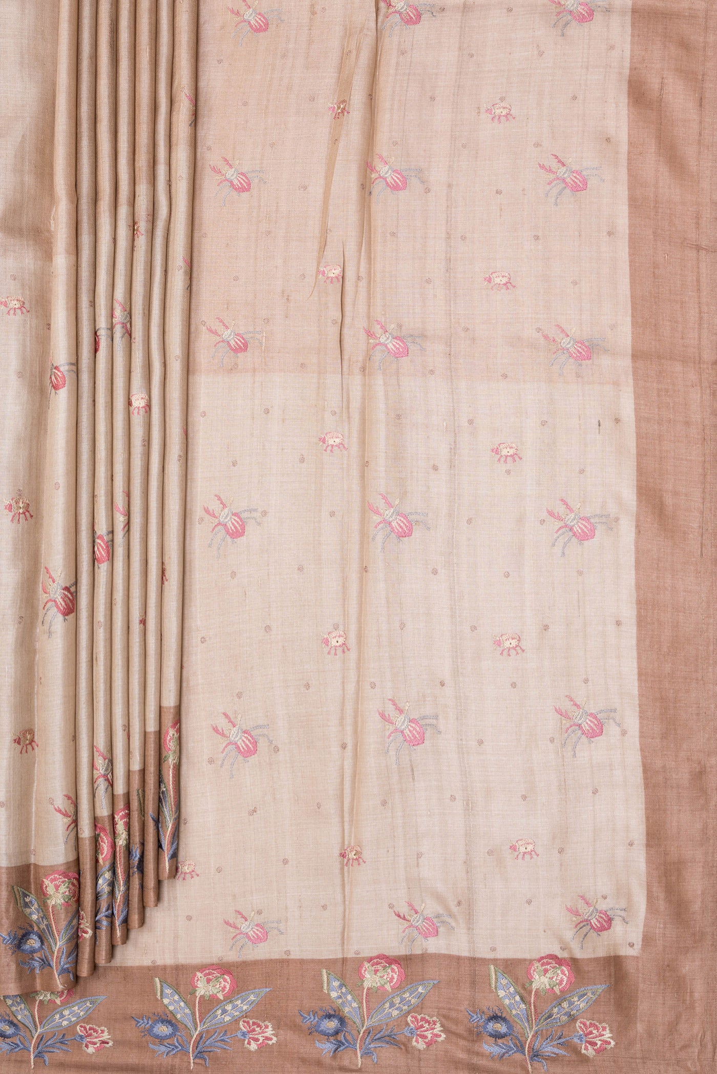 Pleats and pallu of Beige Tussar Silk Saree with Embroidery on the body and Embroidery Border. 