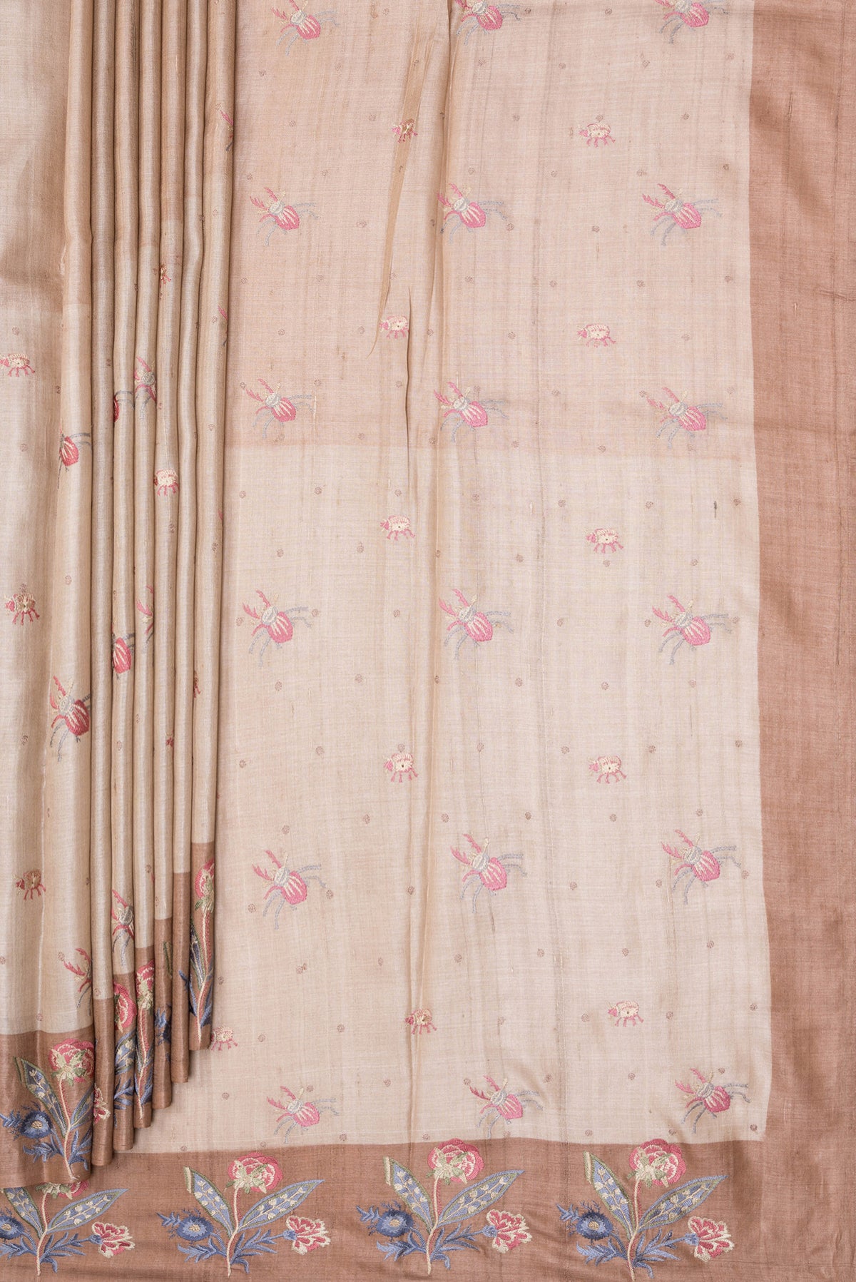 Pleats and pallu of Beige Tussar Silk Saree with Embroidery on the body and Embroidery Border. 