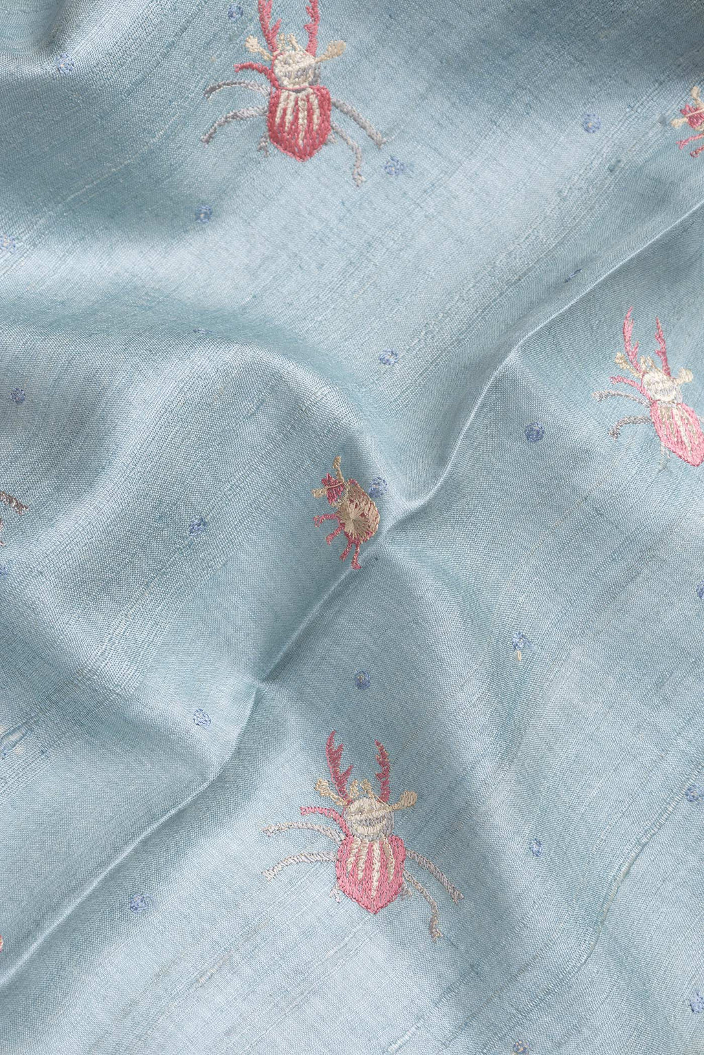Close up of Grey Dual Tone Tussar Silk Saree with Thread Butta on the body and Embroidery Border.  displaying folds