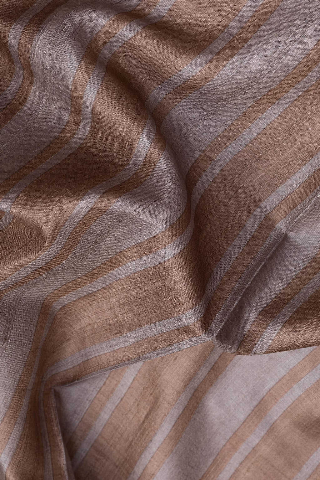 Close up of Grey Dual Tone Tussar Silk Saree with Stripes on the body and Embroidery Border.  displaying folds