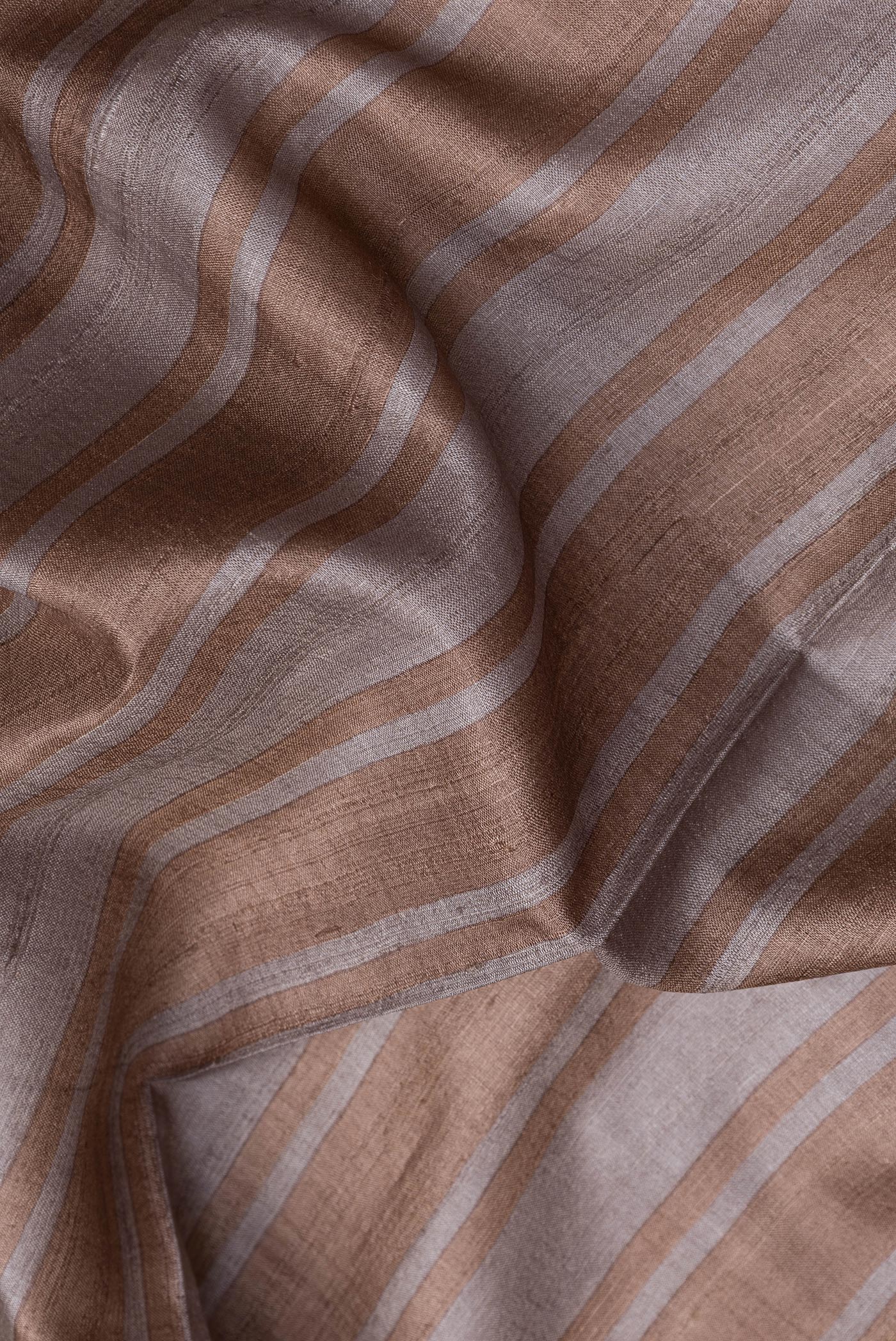 Close up of Grey Dual Tone Tussar Silk Saree with Stripes on the body and Embroidery Border.  displaying folds