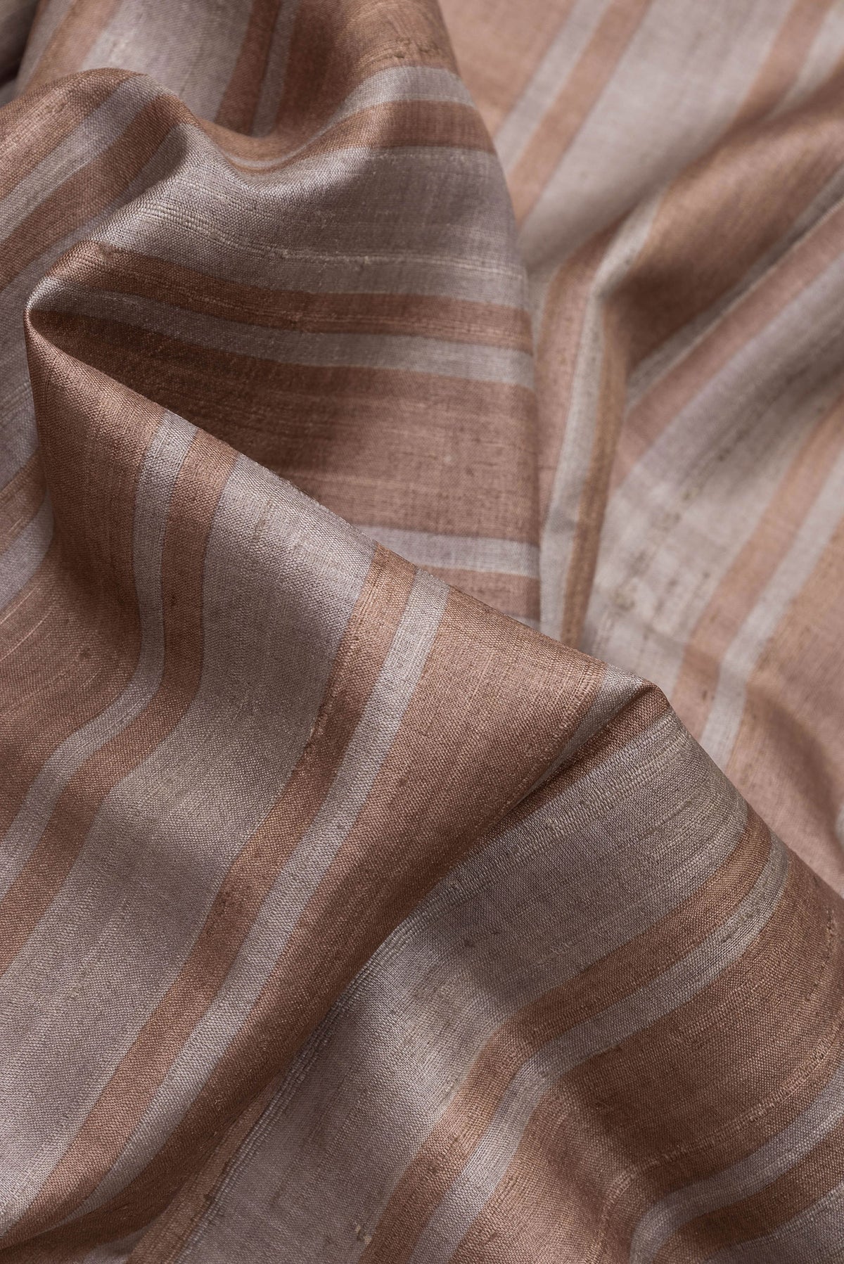 Close up of Grey Dual Tone Tussar Silk Saree with Stripes on the body and Embroidery Border.  displaying folds