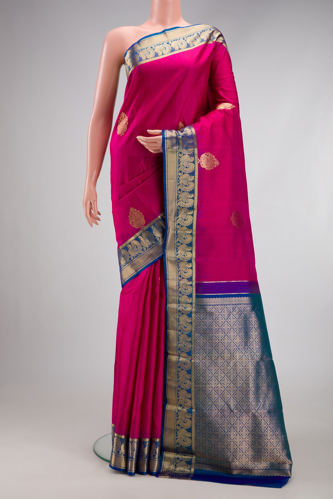 Pink Kanjivaram Silk Saree with Zari Butta on the body and Zari Border.  displayed on a mannequin