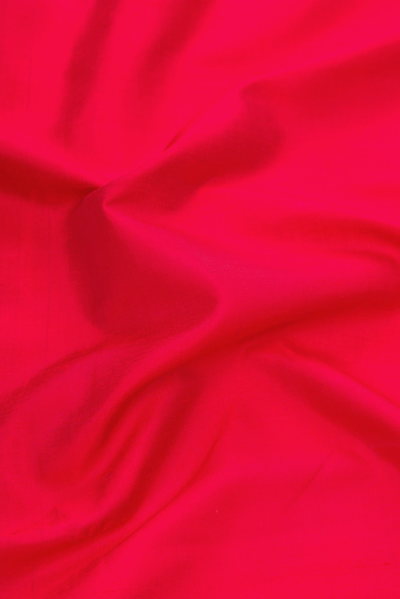 Close up of Red Dual Tone Kanchipuram Silk Saree with Plain Body and Thread Border.  displaying folds