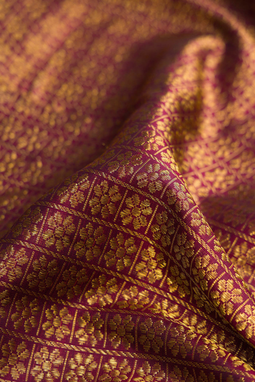 Close up of Burgundy Dual Tone Kanchipuram Silk Saree with Zari Brocade on the body and Zari Border.  displaying folds
