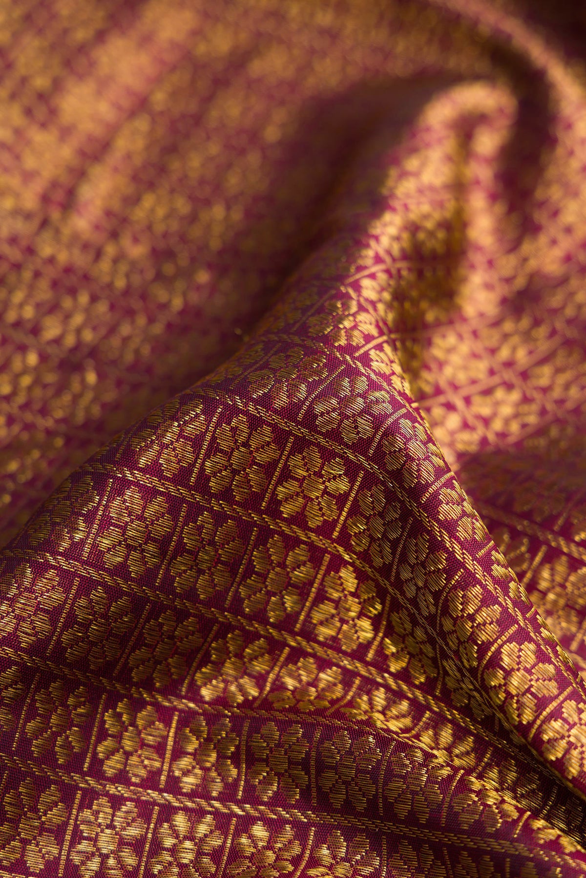Close up of Burgundy Dual Tone Kanchipuram Silk Saree with Zari Brocade on the body and Zari Border.  displaying folds