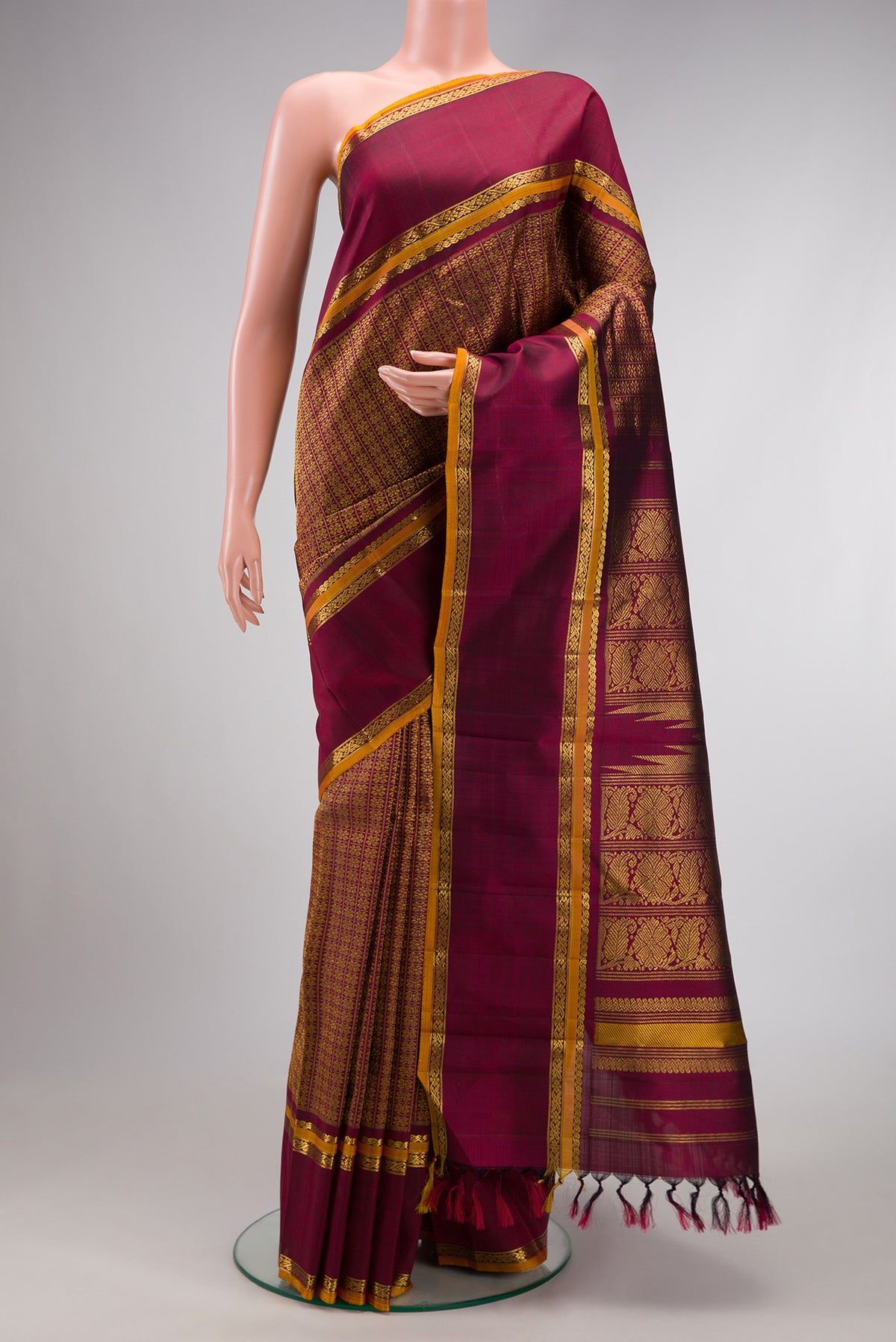 Burgundy Dual Tone Kanchipuram Silk Saree with Zari Brocade on the body and Zari Border.  displayed on a mannequin