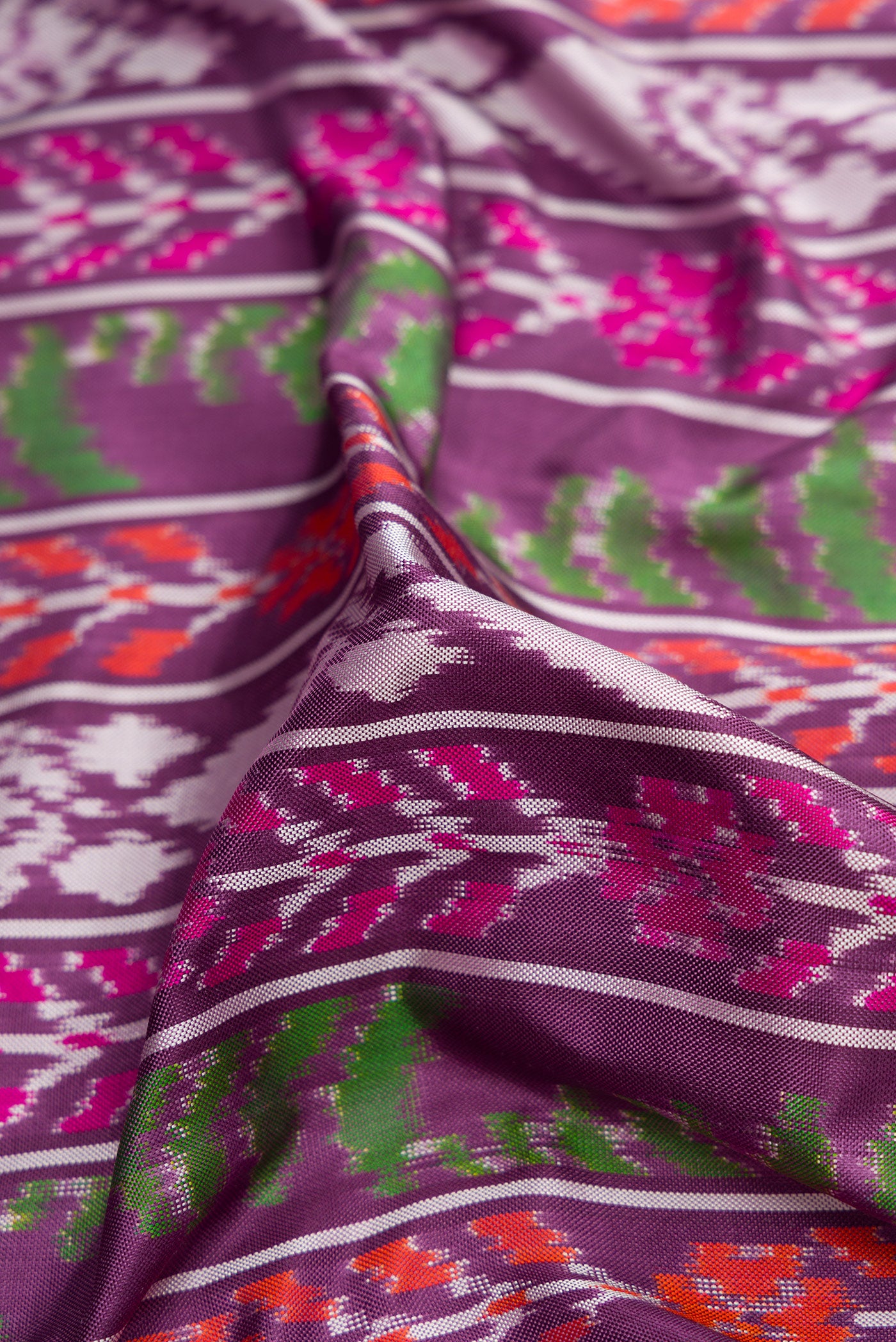 Close up of Purple Dual Tone Double Ikat Saree with Ikat Print on the body and Plain Border.  displaying folds