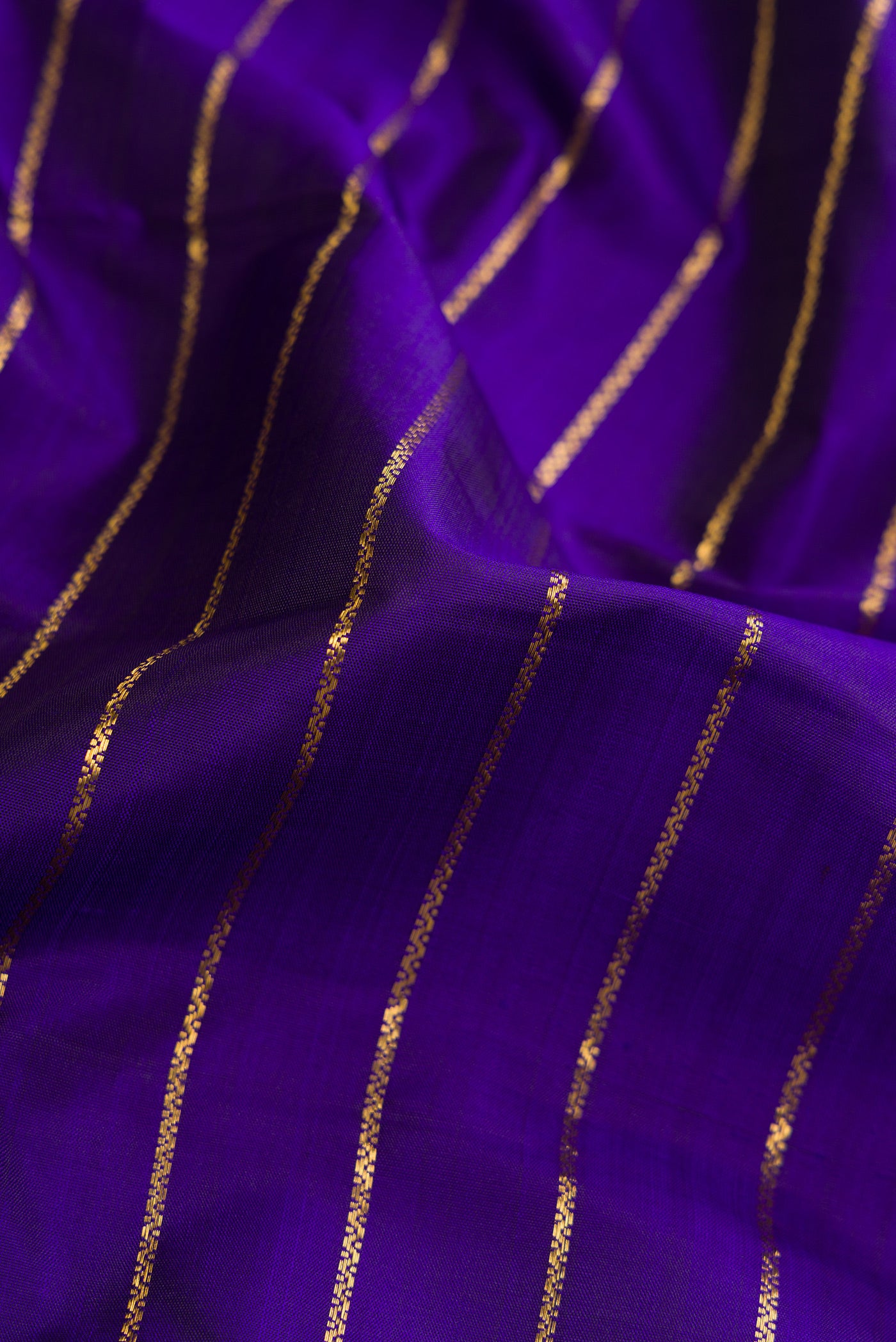 Close up of Royal Blue Dual Tone Kanjivaram Silk Saree with Stripes on the body and Zari Border.  displaying folds