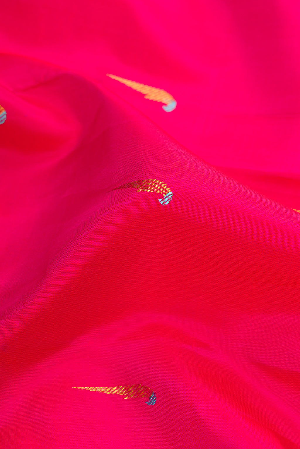 Close up of Pure Silk Pure Zari Pink Dual Tone Kanjivaram Saree with Zari And Thread Butta on the body and Thin Zari Line.  displaying folds