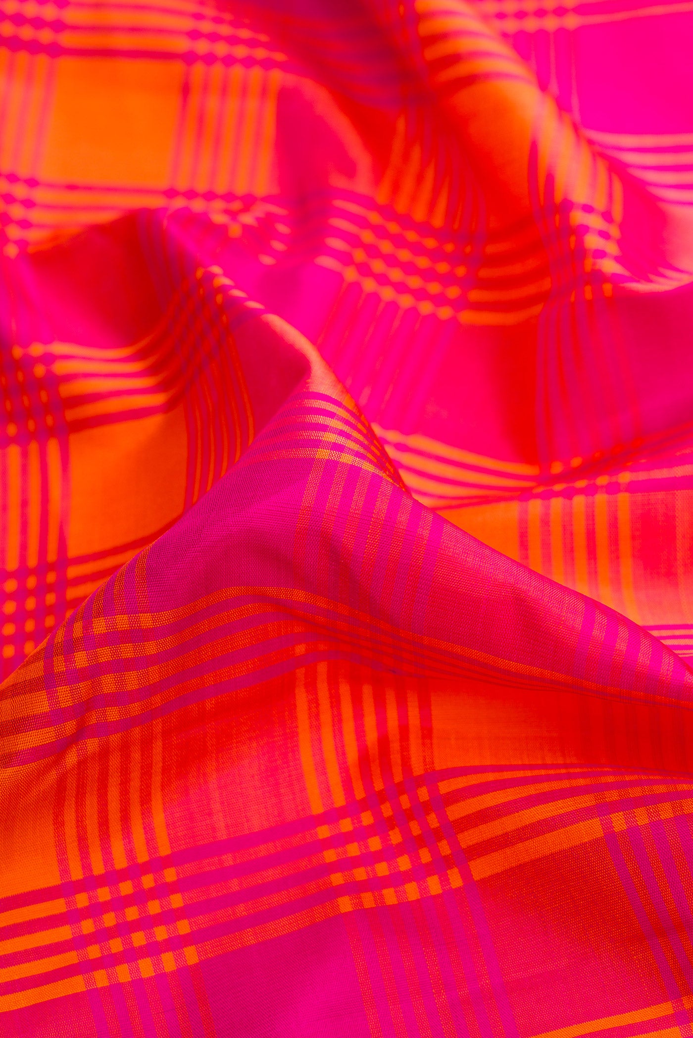Close up of Pure Silk Pure Zari Orange and Pink Color Kanjivaram Saree with Checked design on the body and Zari Border.  displaying folds