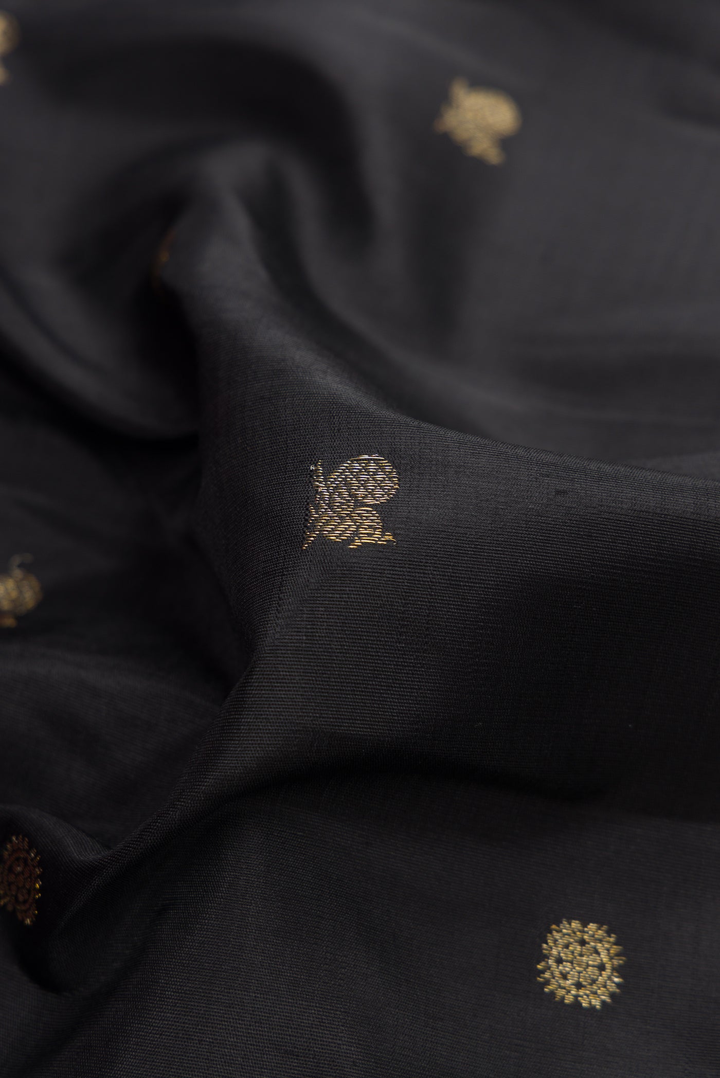 Close up of Pure Silk Pure Zari Coffee Brown Dual Tone Kanjivaram Saree with Zari Butta on the body and Zari Border.  displaying folds