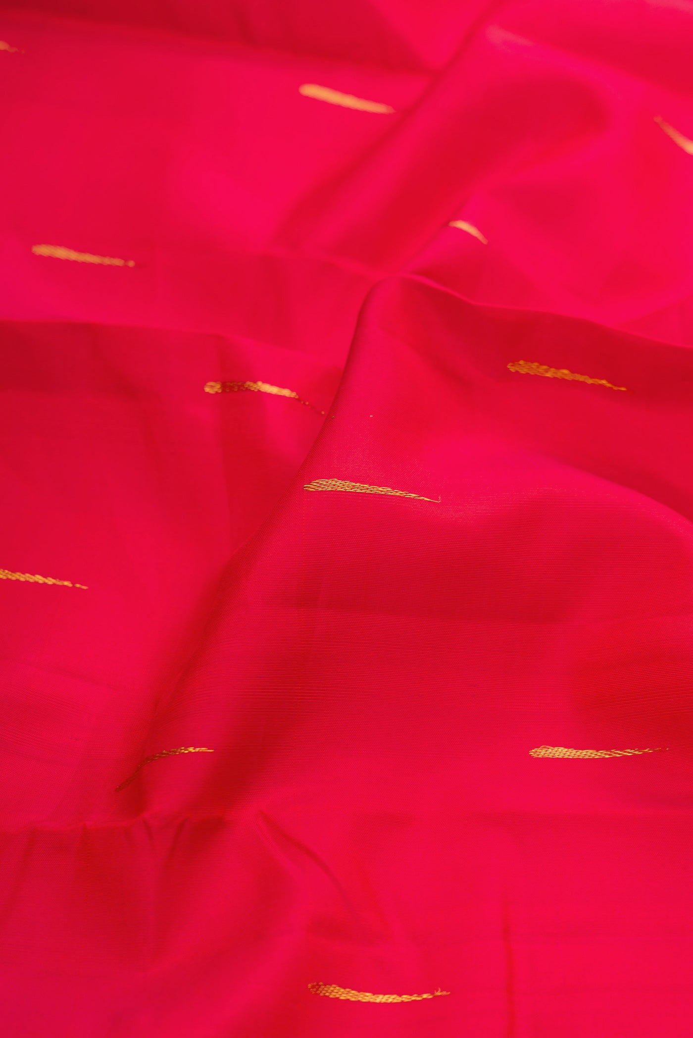 Close up of Red Kanjivaram Silk Saree with Zari Butta on the body and Zari Border.  displaying folds